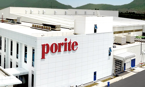 Exterior view of a large white industrial building with the red 'porite' logo on the side.