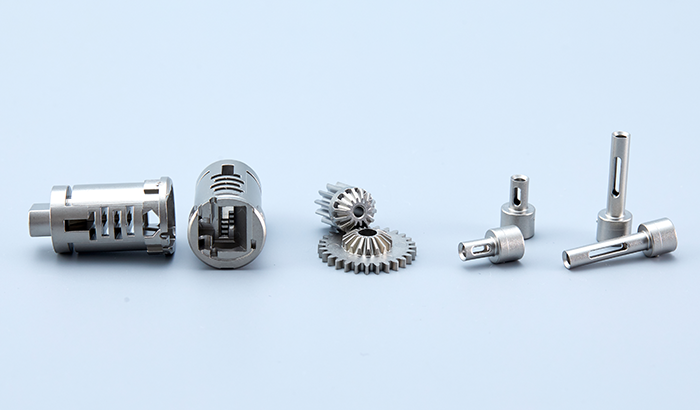 Set of small metallic spark plugs and internal engine components on a light blue background.