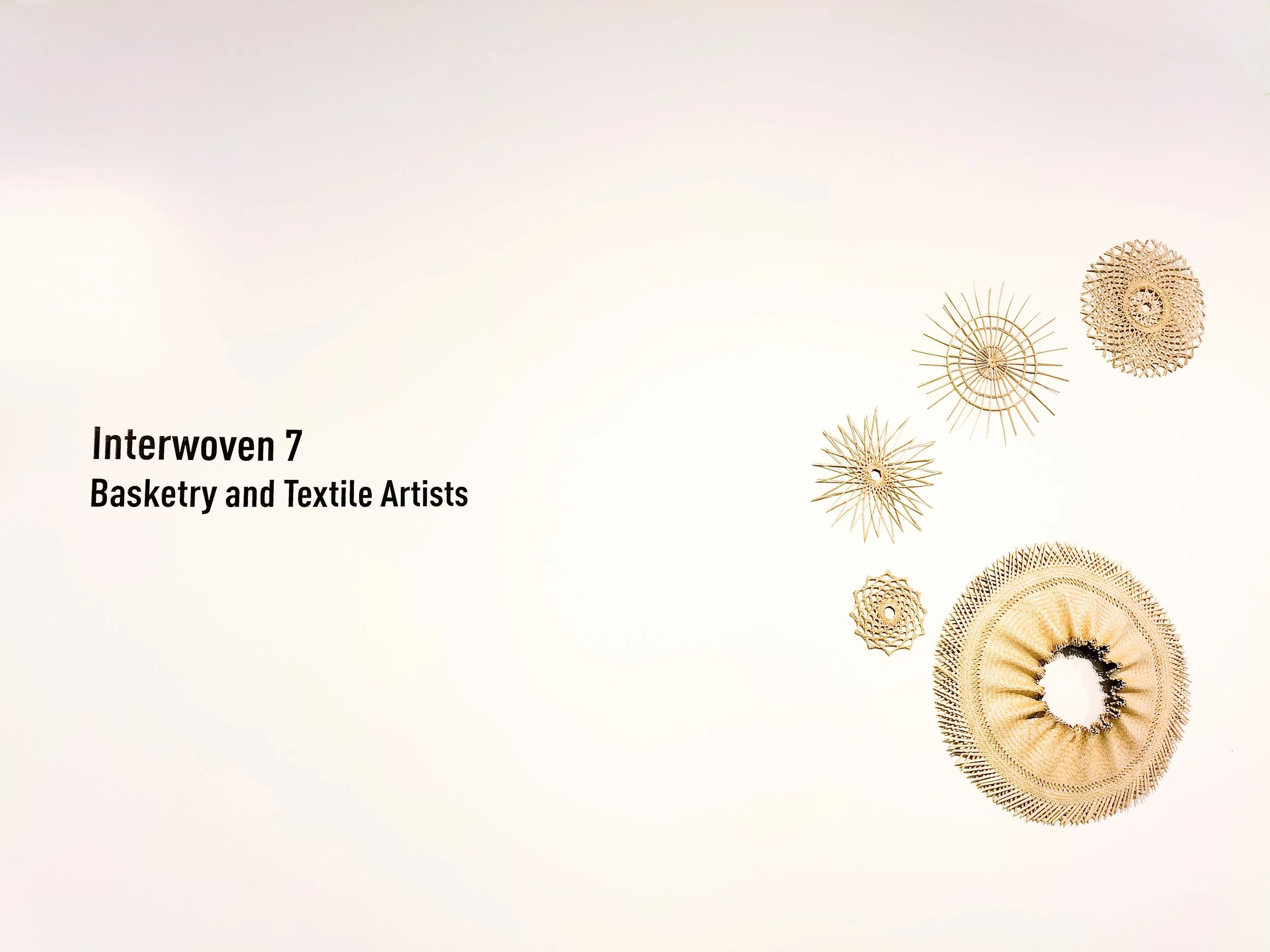 Collection of intricately woven basketry and textile art pieces arranged on a beige background.