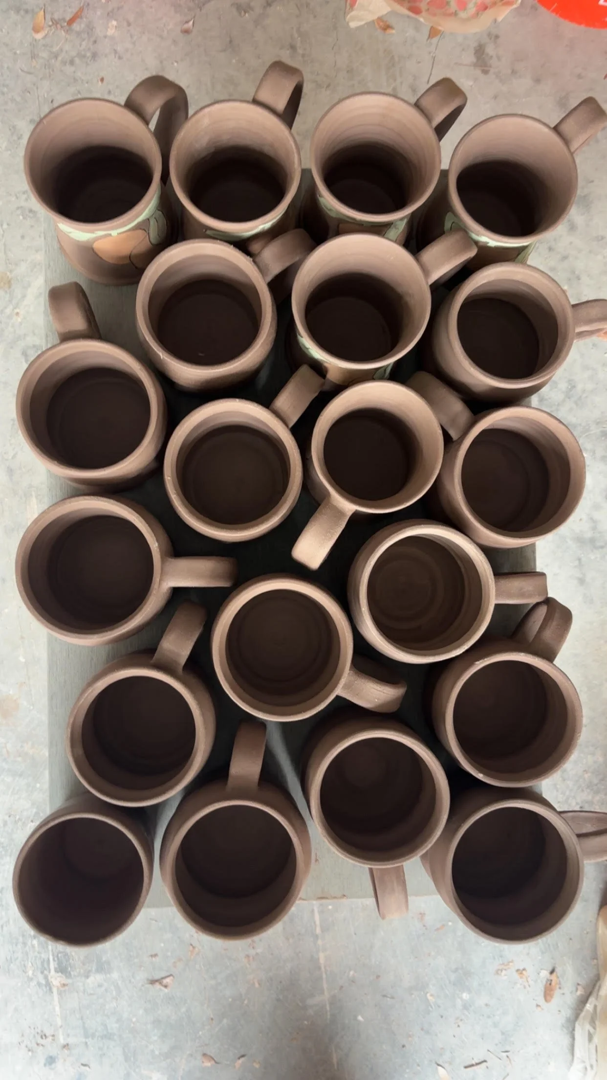 Top-down view of multiple ceramic coffee mug arranged on a surface.