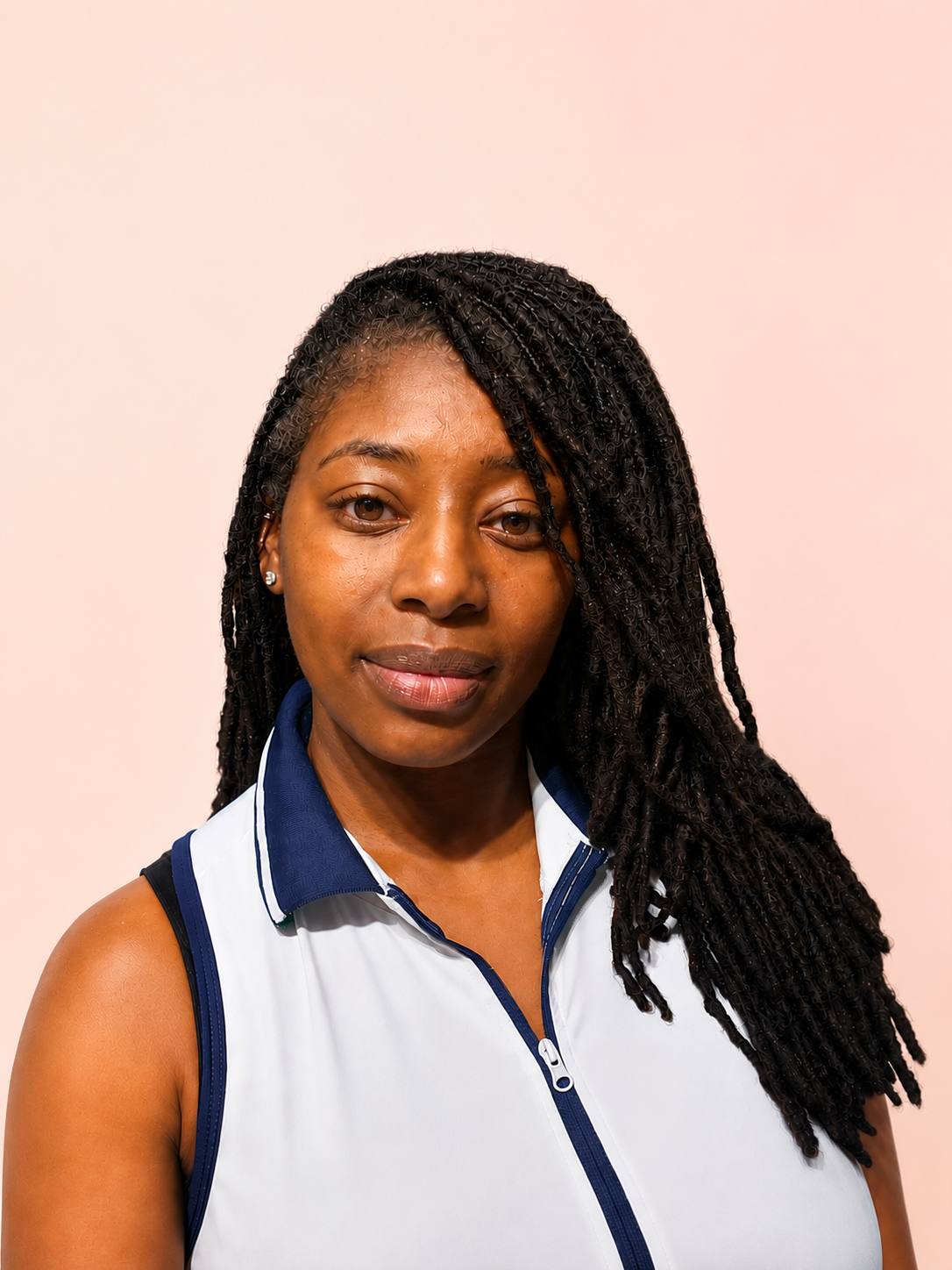 Portrait of a woman with long braided hair wearing a white and blue sleeveless sports top, standing against a plain light-colored background.