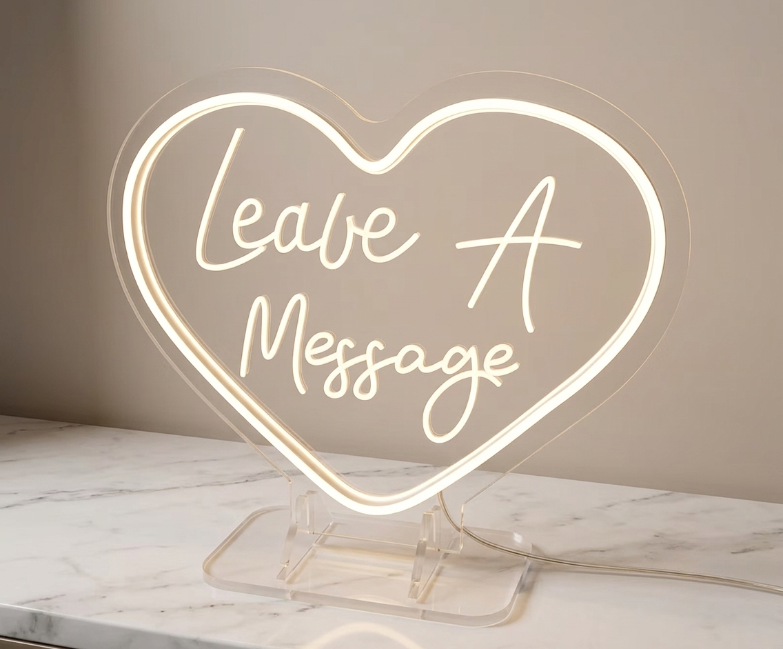 Acrylic display stand for audio guestbook services. Heart-shaped neon sign with 'Leave A Message' in cursive.