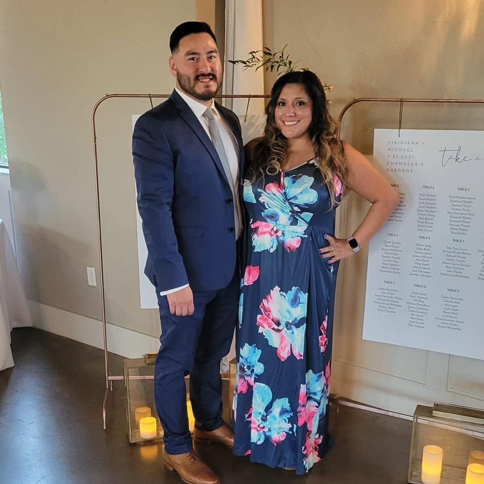 John and Debbie, owners of Memories Out Loud audio guestbook rentals, posing together in formal wear at a wedding reception venue.