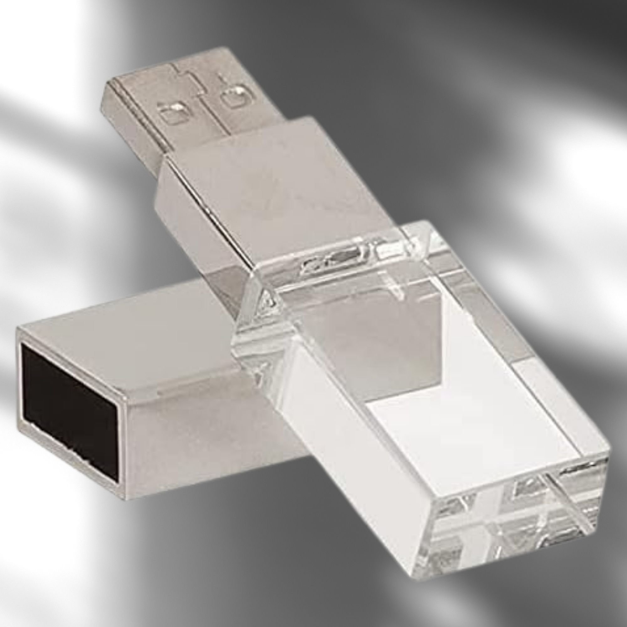 Promotional custom USB flash drive featuring a silver metal connector body and a clear crystal glass section that lights up with LED. The metal cap is removed and resting beside the drive.