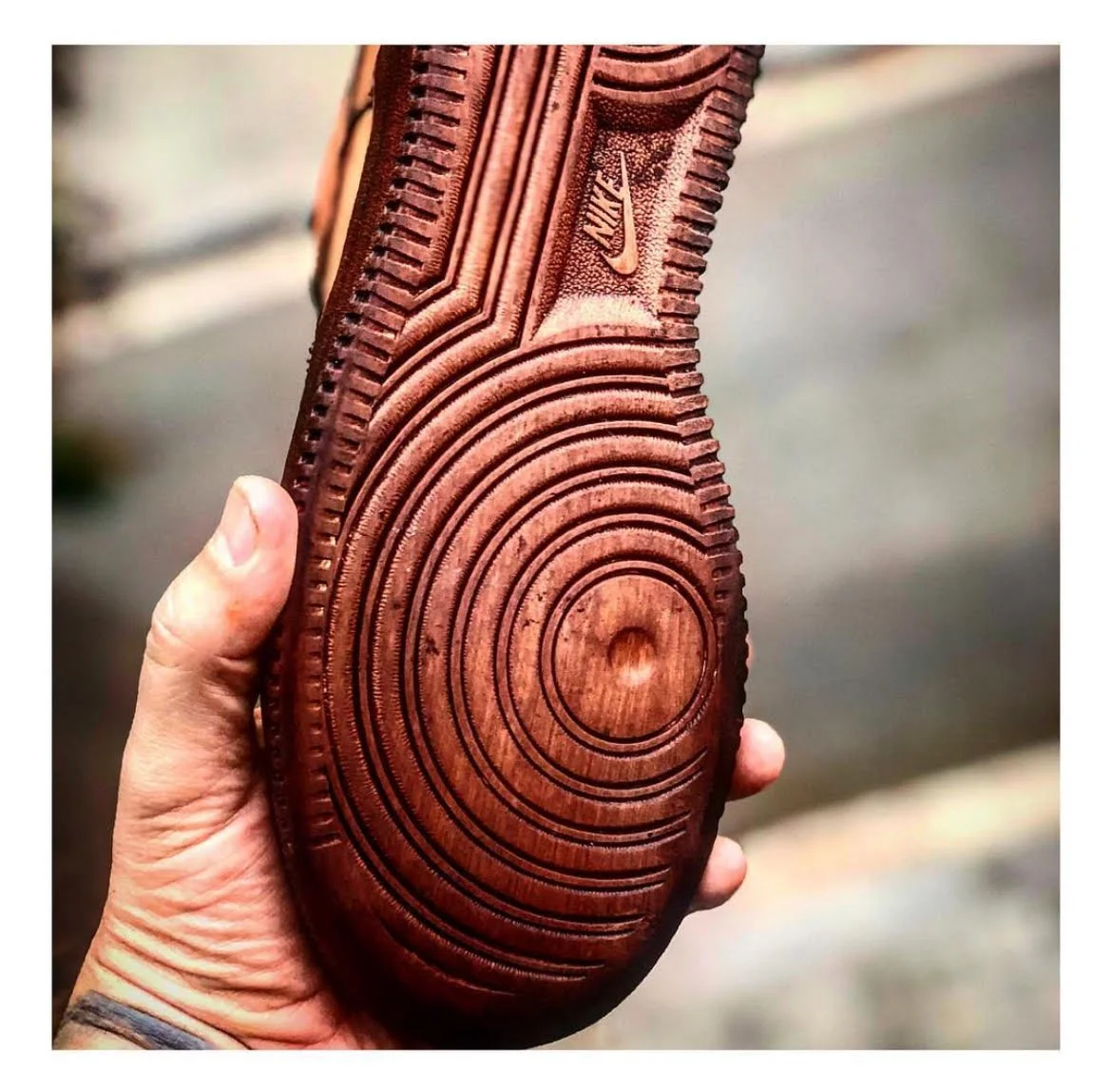 Suela de zapato de color marrón con diseño de círculos y líneas, y logotipo de Nike.