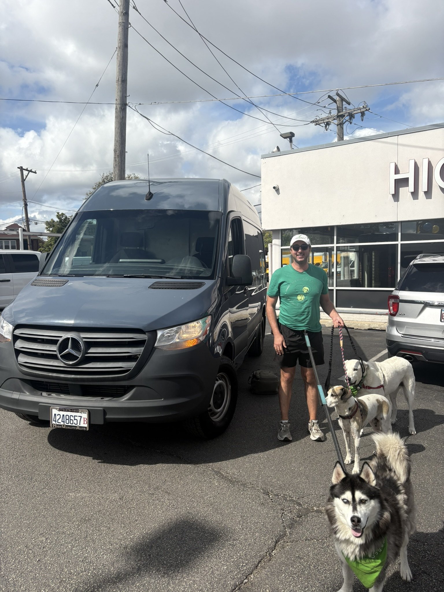 Jared Hocking with Chicago Adventure Pack dogs beside the adventure van used for pickup and drop-off