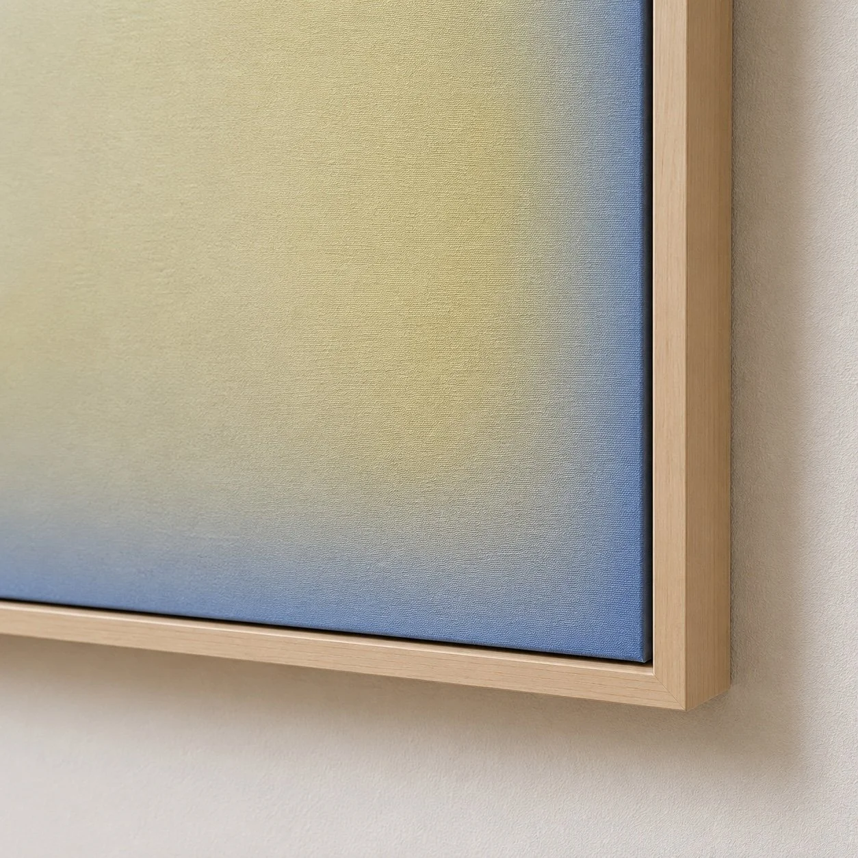 Close-up of a framed blue fabric-covered board on a beige wall.