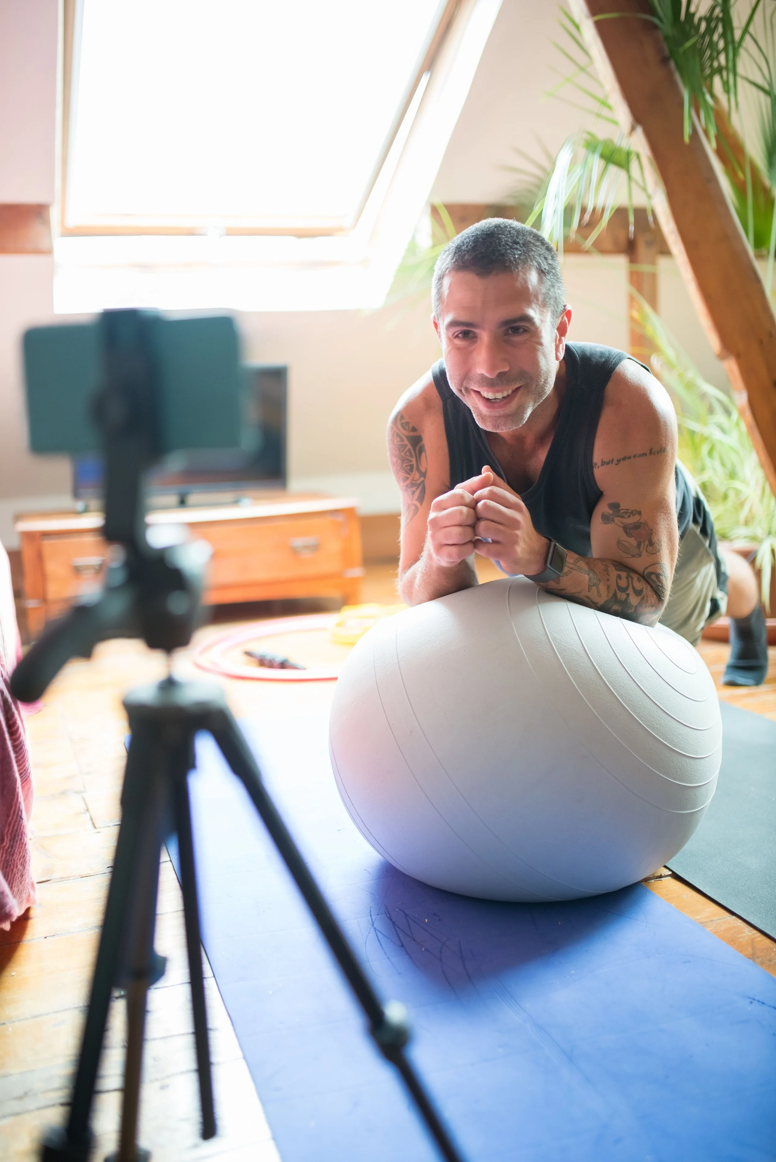 Man performing a stability exercise with a large fitness ball on a mat