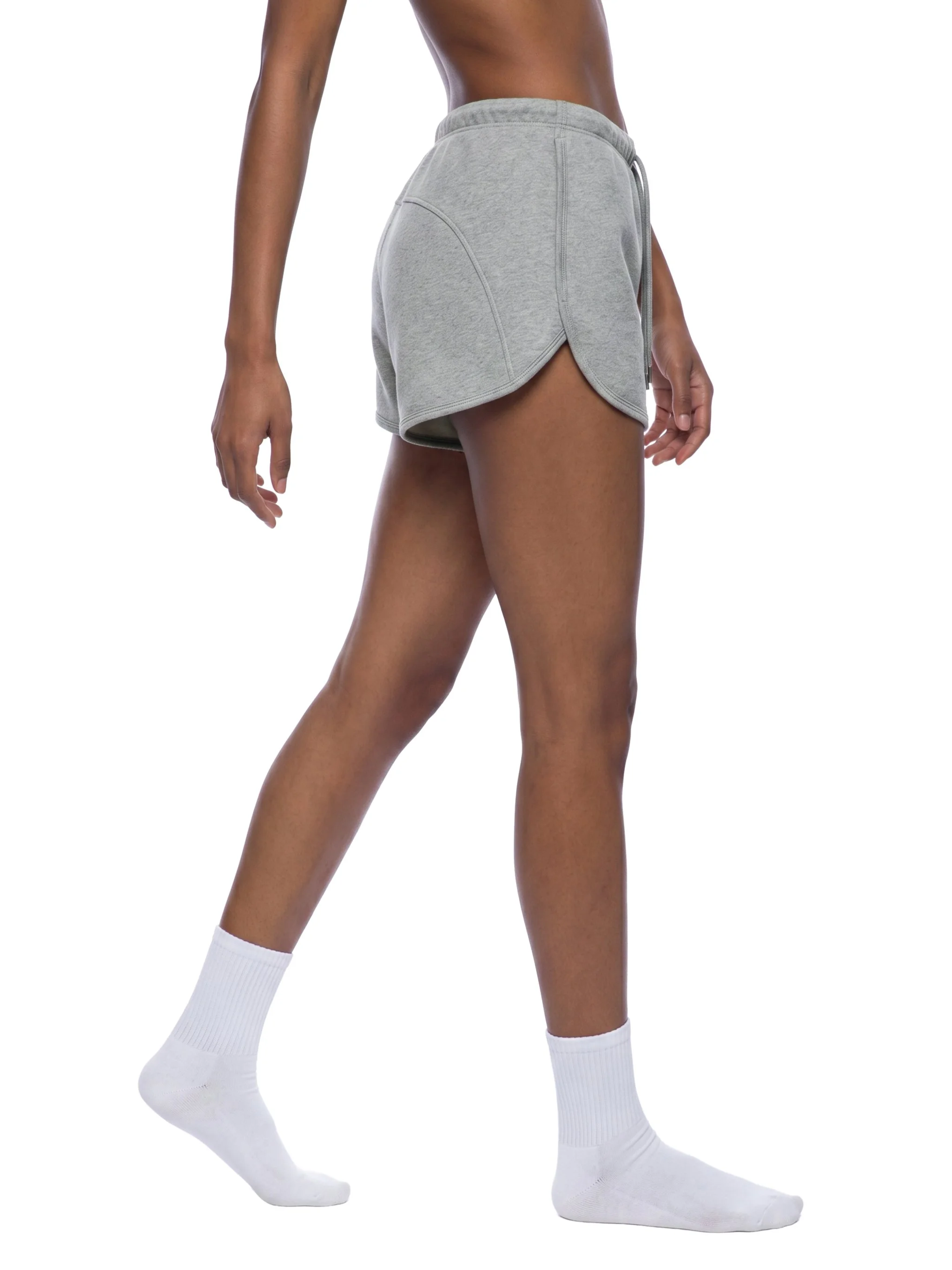 Close-up of a person wearing gray athletic shorts and white knee-high socks.