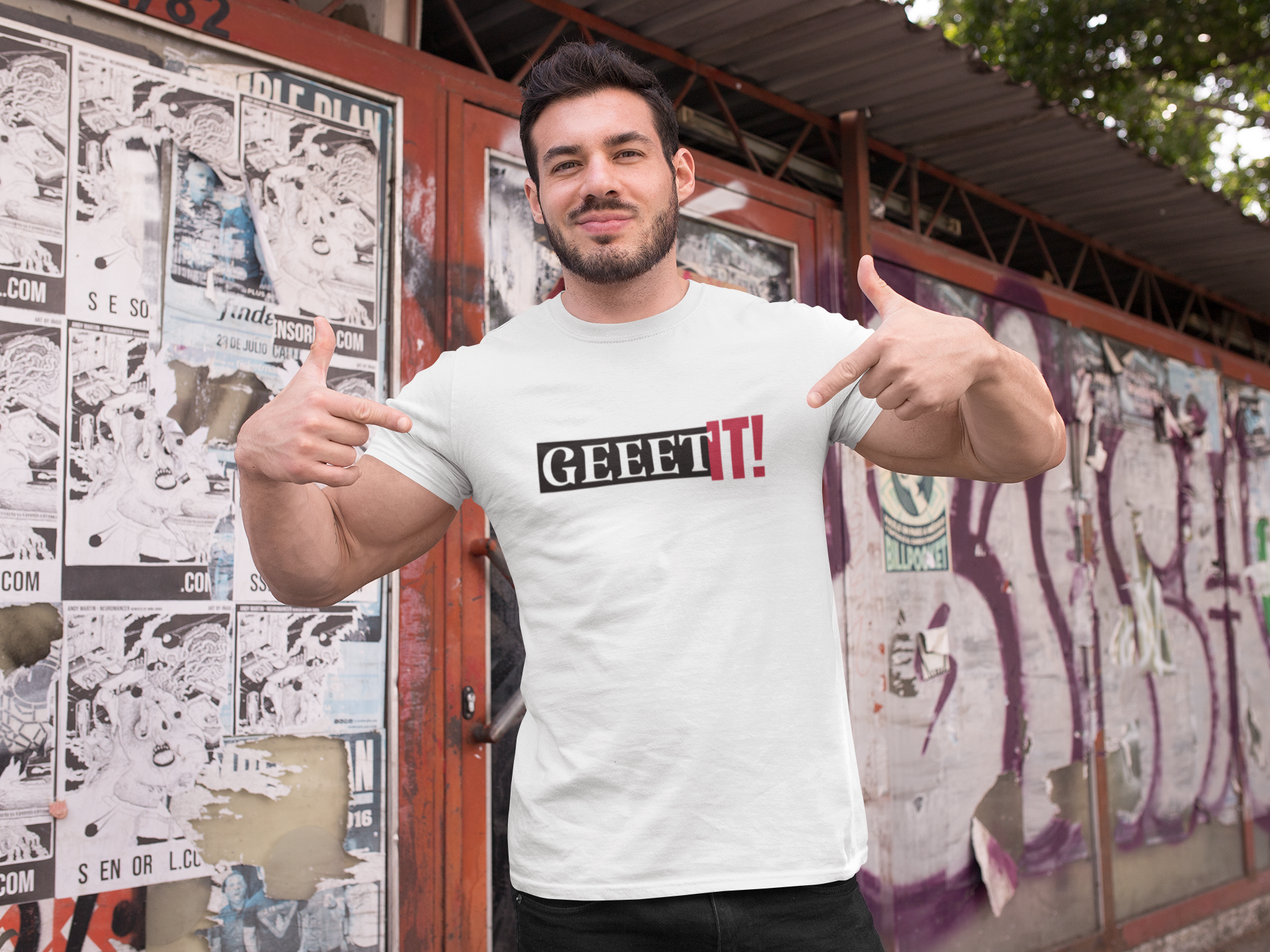 Man modeling a white Geeet IT! fitness T-shirt in front of a poster wall