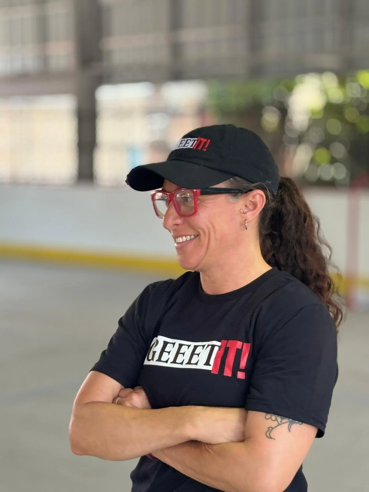 Geeet IT! coach wearing branded apparel inside an indoor community sports facility