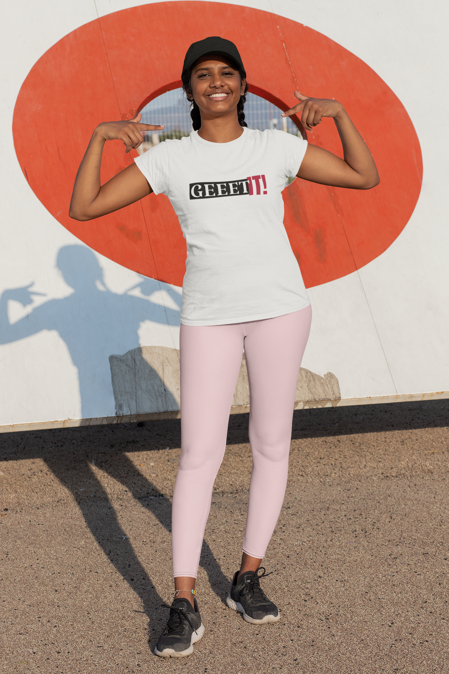 Woman modeling a white Geeet IT! T-shirt with pink leggings outdoors