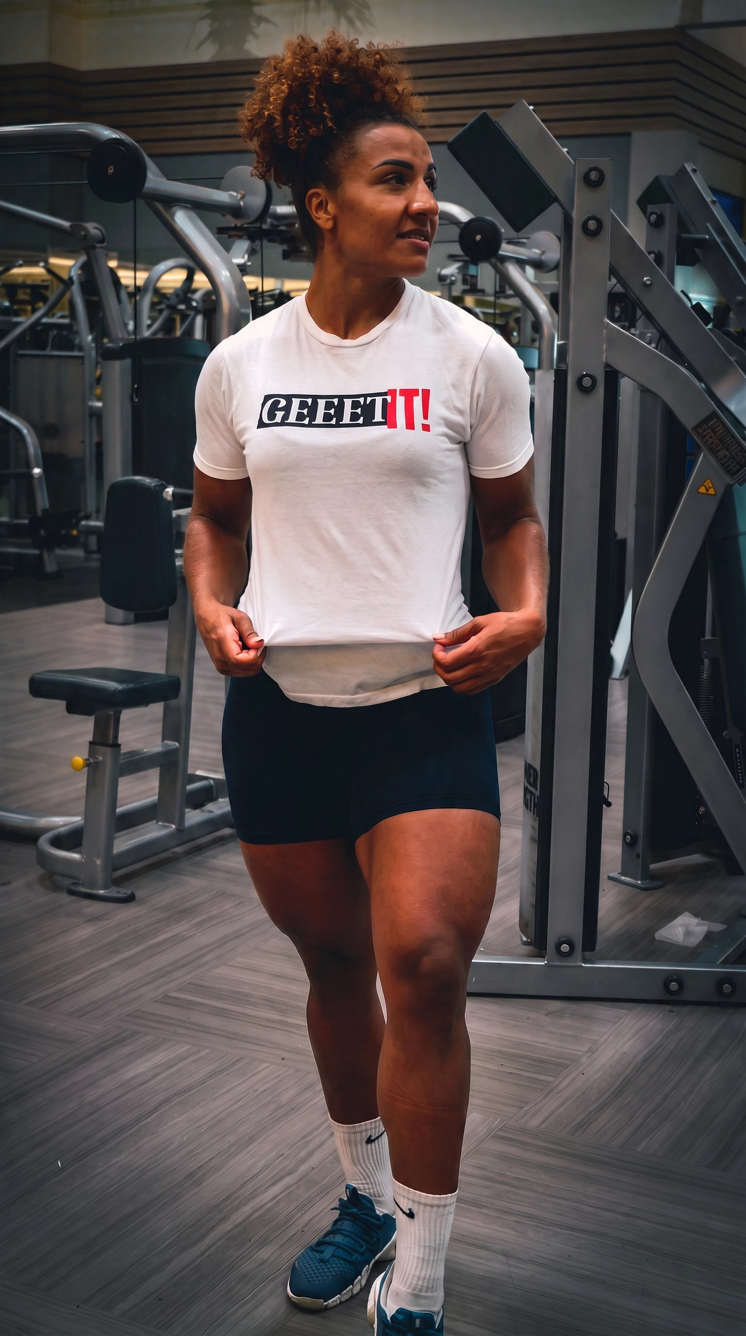 Woman wearing a white Geeet IT! shirt inside a gym