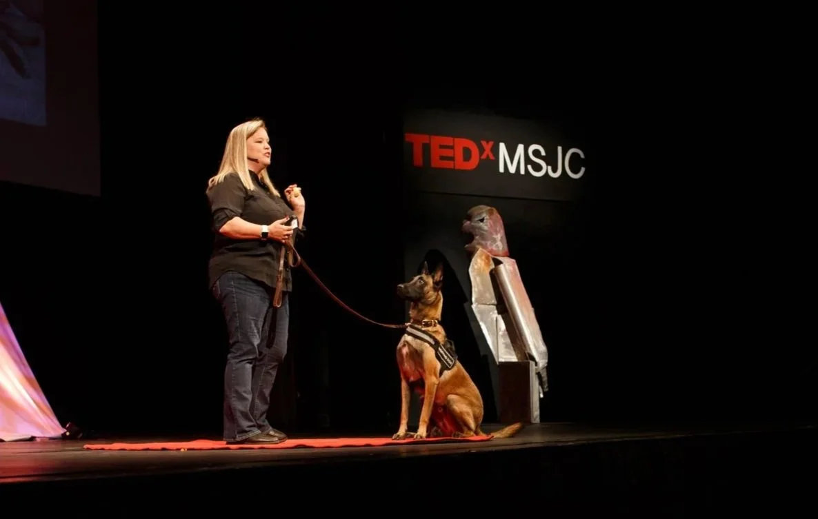 Green Dog co-founder Deanna Kjorlien and K9 Jimmy during a TEDx talk highlighting the science and effectiveness of K9 bed bug detection.