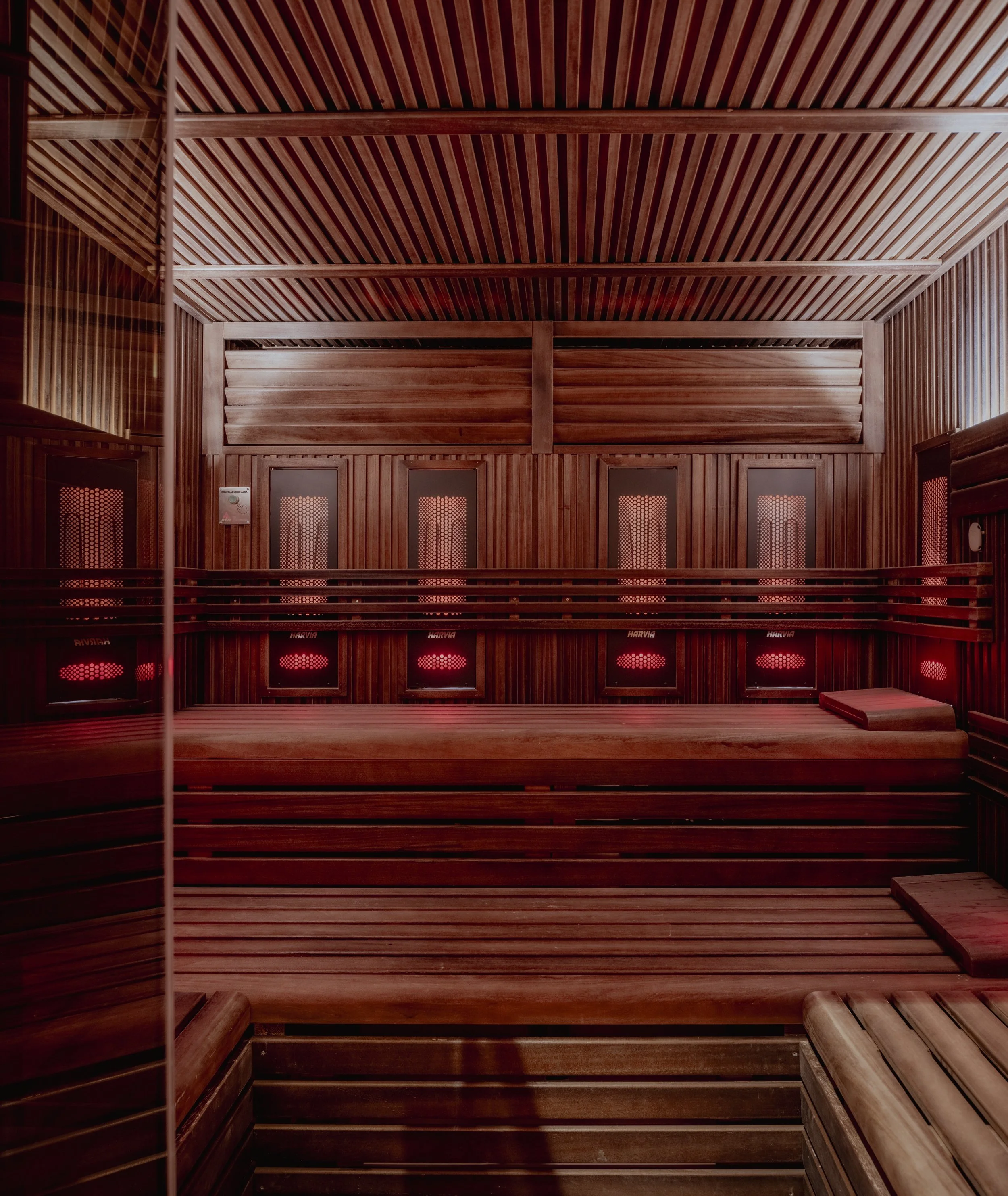 Interior de la sauna con paredes de madera y luz roja