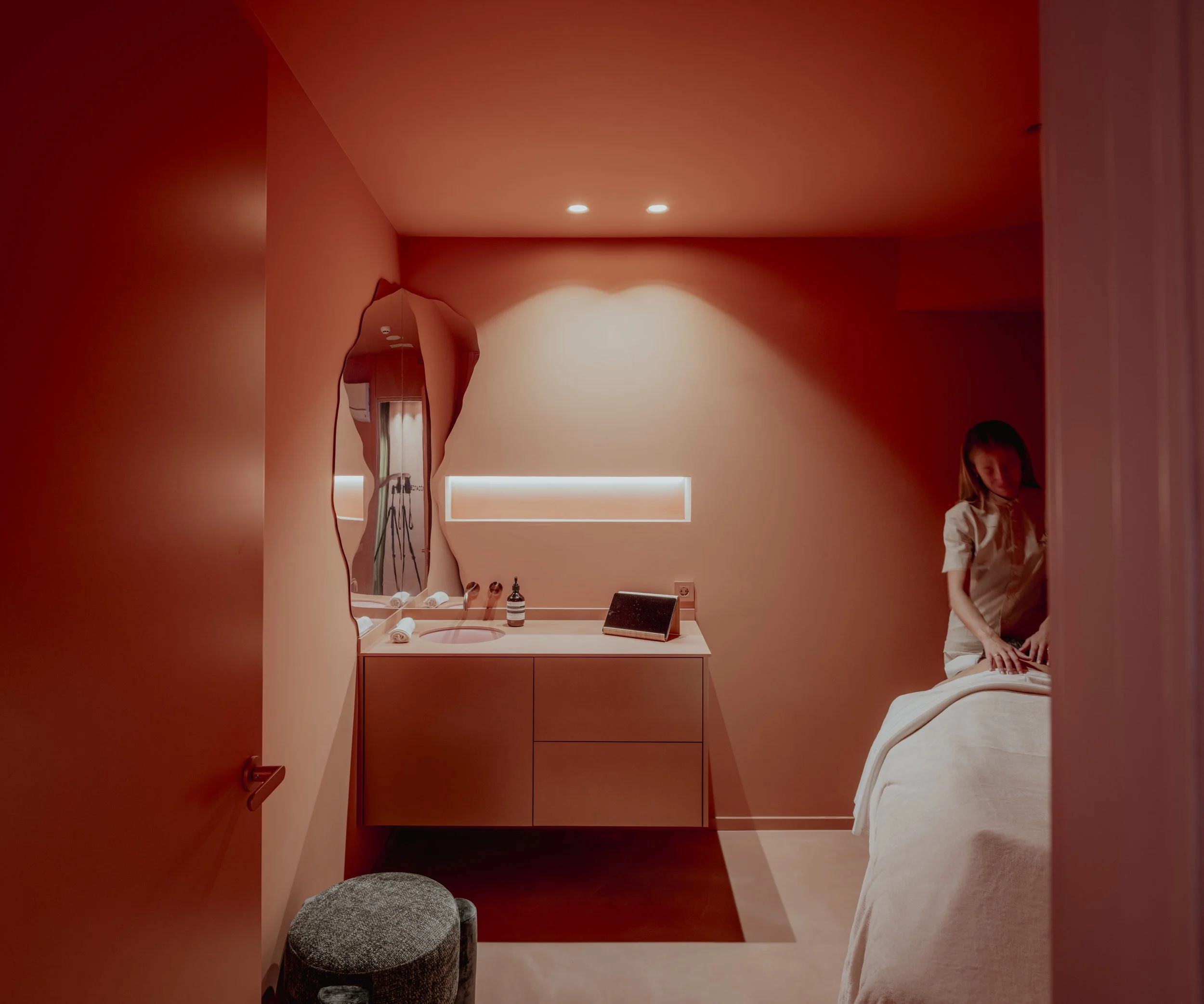 Sala de tratamiento en tonos rojos con camilla