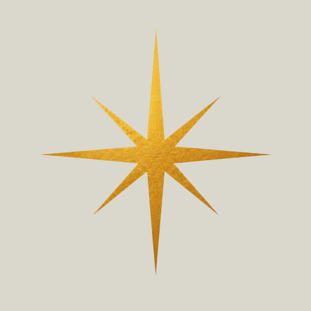 A gold starburst ornament with eight points on a plain light background.
