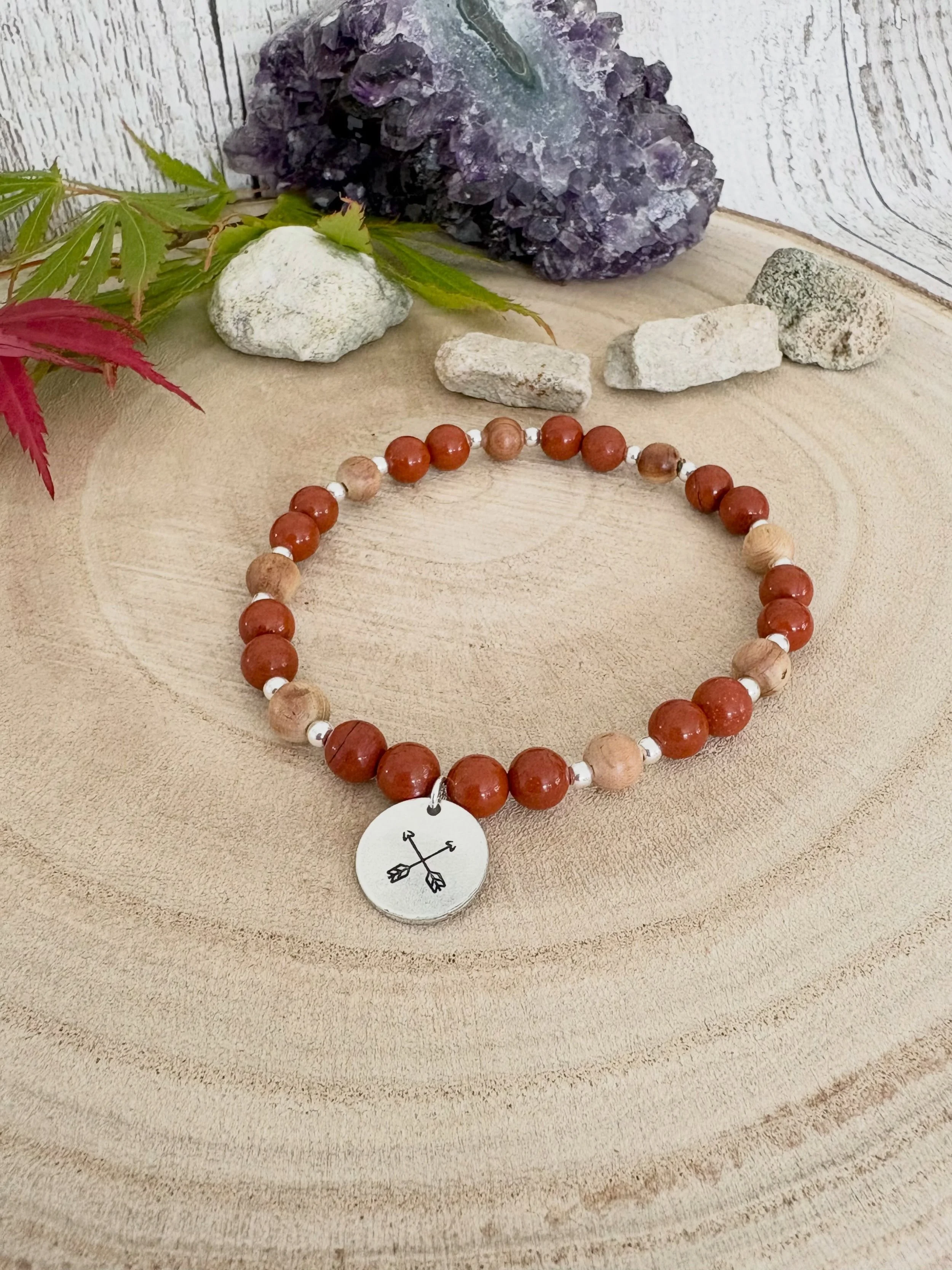 Red Jasper and cedar wood bracelet with a crossed arrow hand stamped charm to symbolise friendship and community! Sometimes that what we need in life; our tribe and our community to support us! 

Red Jasper is symbolic of endurance, perseverance, str