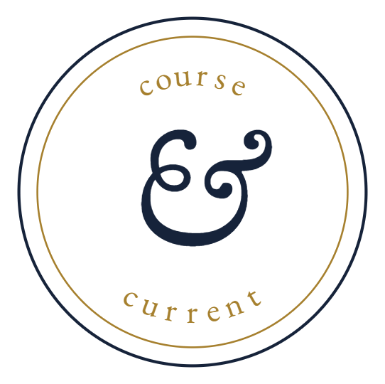 A circular logo with a black background and gold and navy blue text that reads 'course & current' with an ornate ampersand in the center.