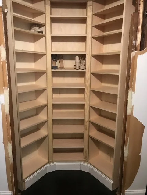 Custom corner wooden pantry with multiple shelves, created by our woodworking team.