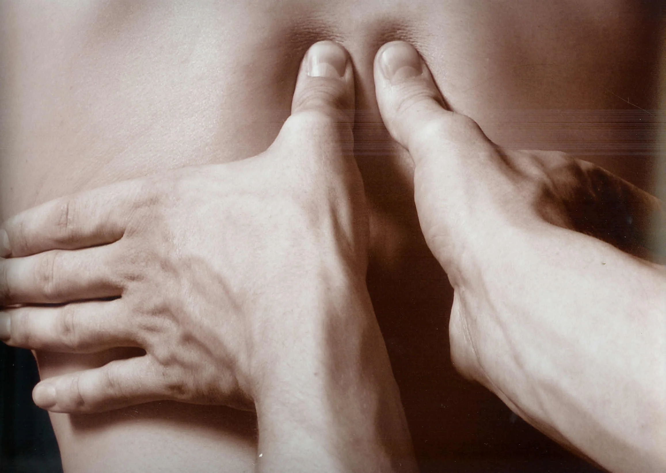 Close-up of a person's body with fingers pressing into the skin and creating indents.