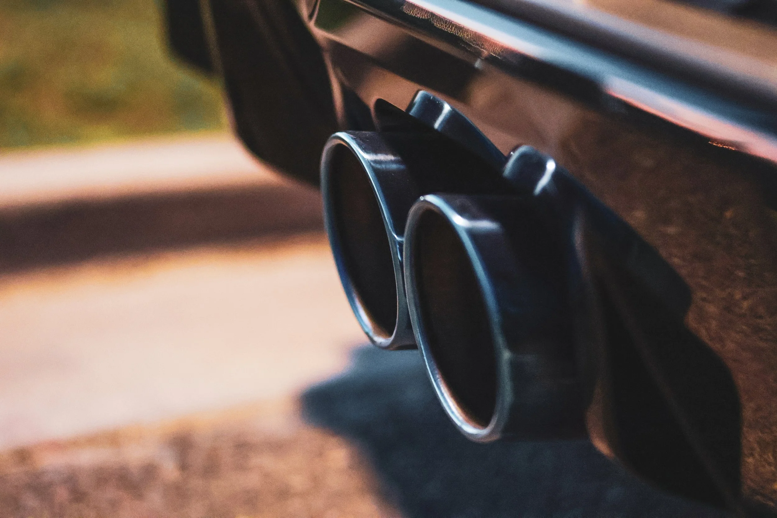 An artistic macro shot of two beautifully heat-blued exhaust tips on a Mini Cooper John Cooper Works JCW taken at night in Morrison Ranch in Gilbert, AZ..