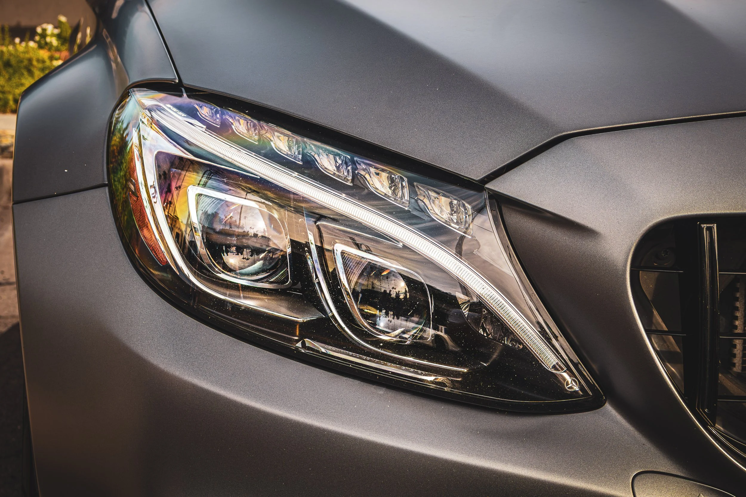 Macro detail automotive photography focusing on the intricate LED headlight assembly and smooth satin gray paint of a Mercedes-AMG C63S Edition 1 in Arizona, shot by Curtis for Gasoline and Dopamine