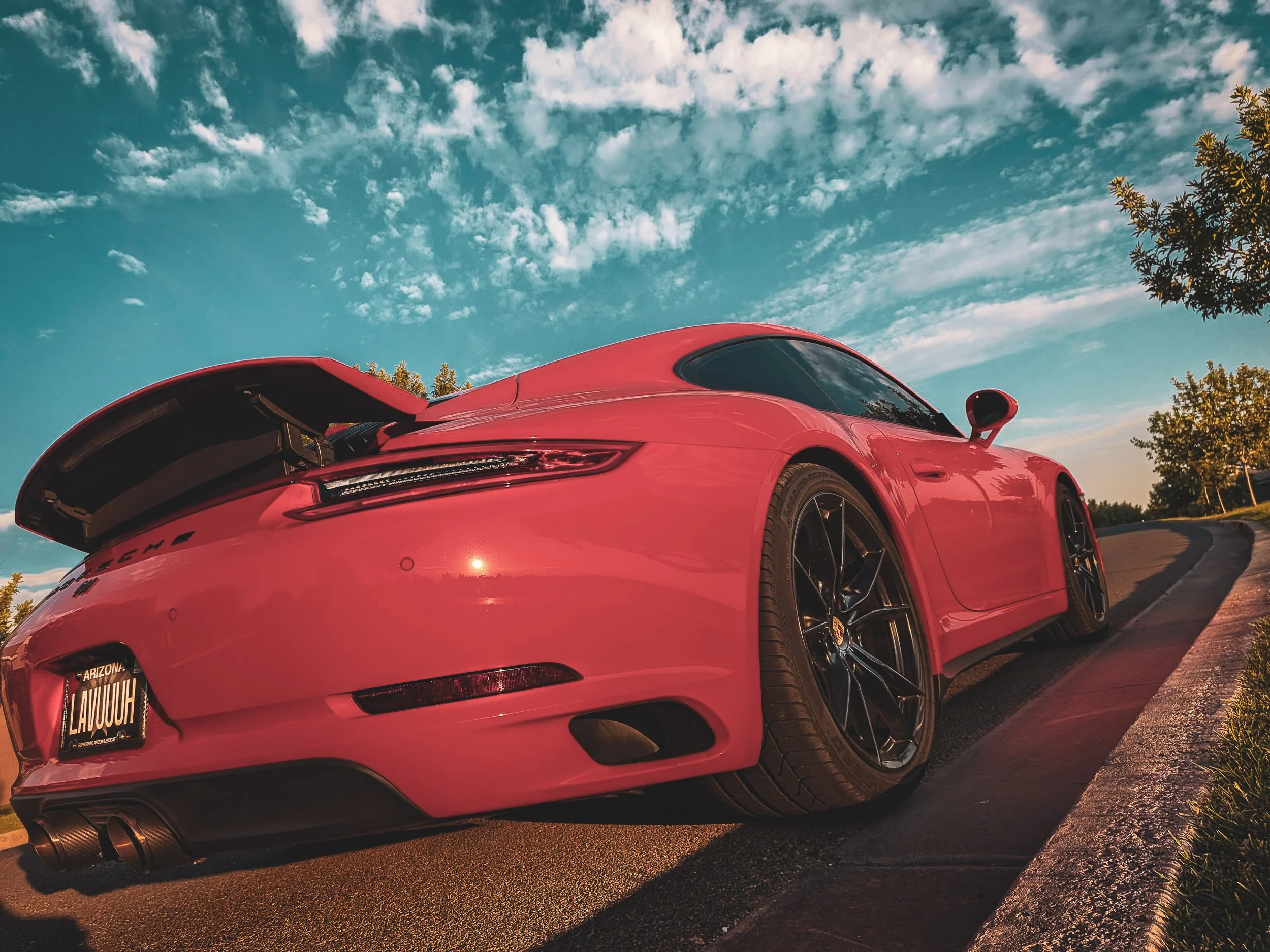 Dynamic street car photography of a Lava Orange Porsche 911 captured under a dramatic sunset sky in Gilbert, Arizona, serving the Phoenix East Valley, shot by Gasoline and Dopamine Automotive Photography.