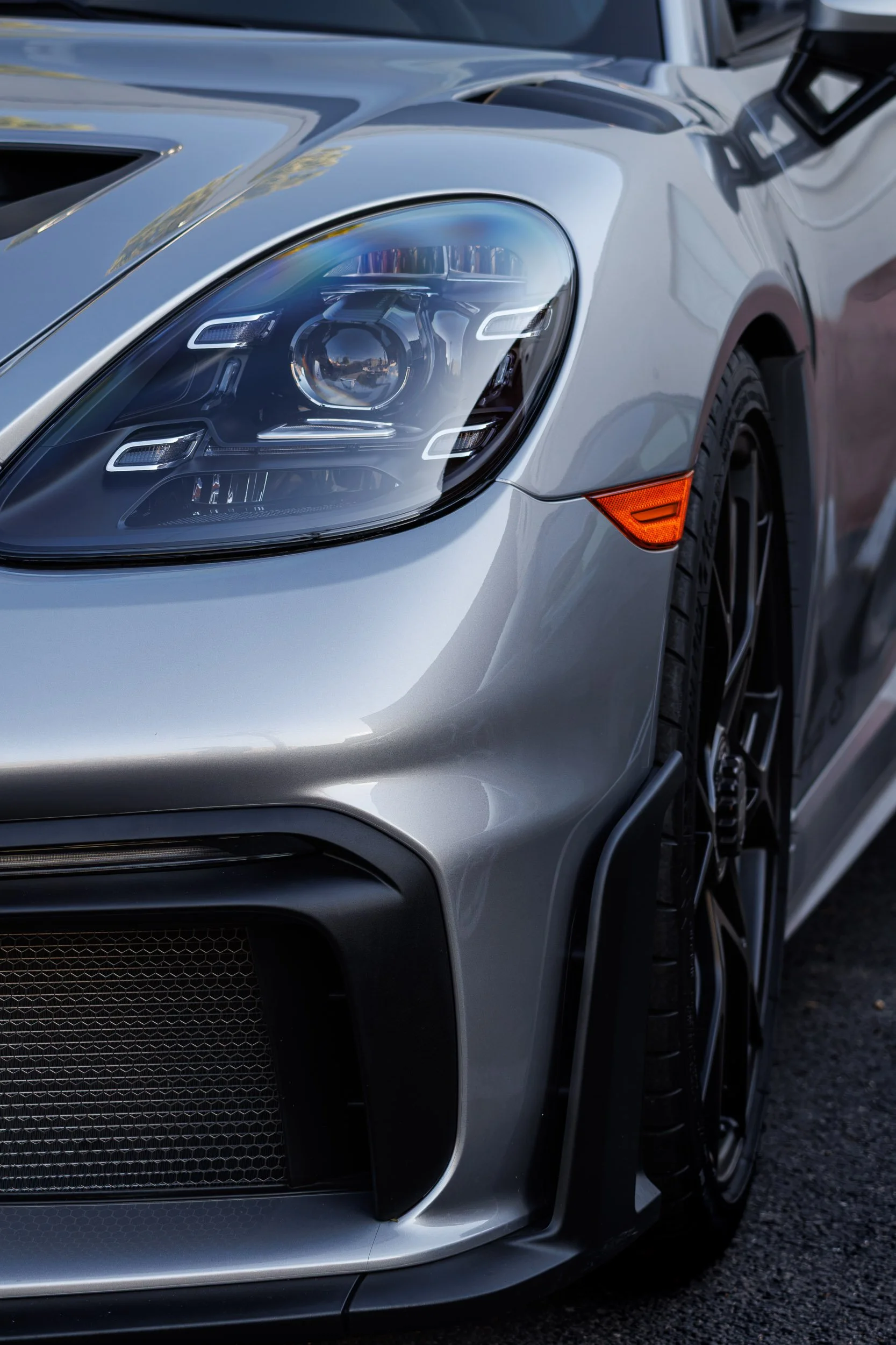 Macro detail car photography highlighting the intricate LED headlight assembly, front fascia aero, and smooth liquid silver paint of a Porsche Spyder RS in Scottsdale, Arizona, captured by Curtis from Gasoline and Dopamine.