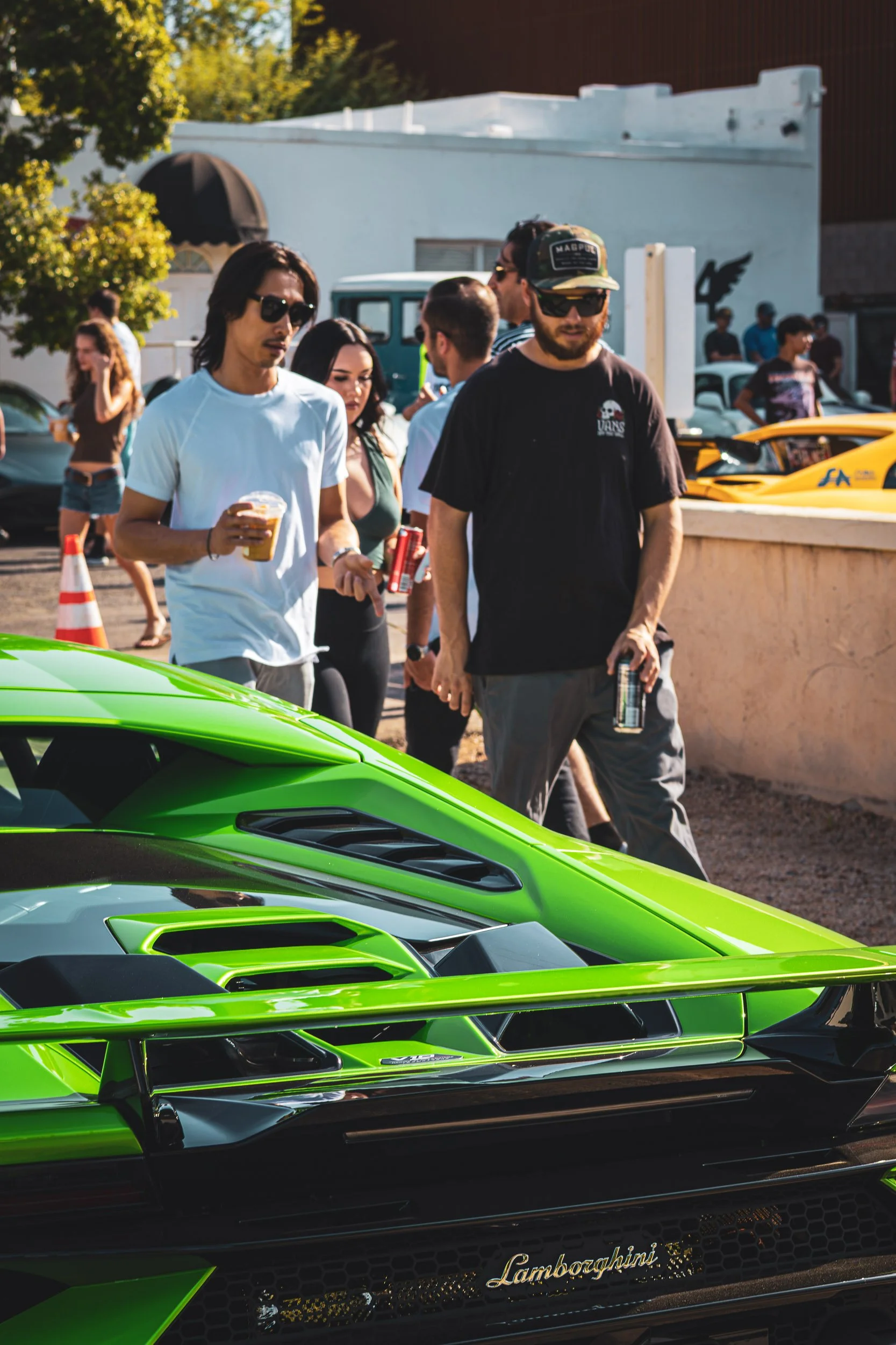 Automotive lifestyle photography capturing enthusiasts walking next to a bright green Lamborghini supercar during a weekend car meet in Scottsdale, Arizona, captured by Gasoline and Dopamine Car Photography.