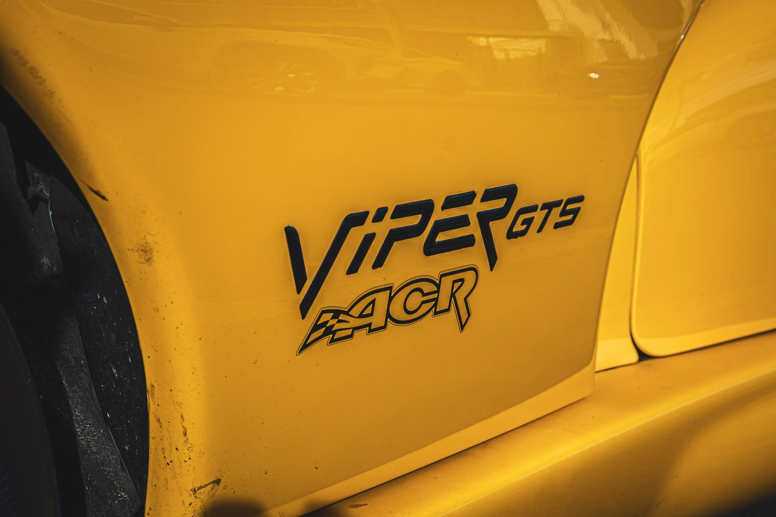 Macro detail automotive photography highlighting the black Viper GTS ACR side decal set against bright yellow paint on a Dodge Viper in Chandler, Arizona, shot by Curtis at Gasoline and Dopamine.