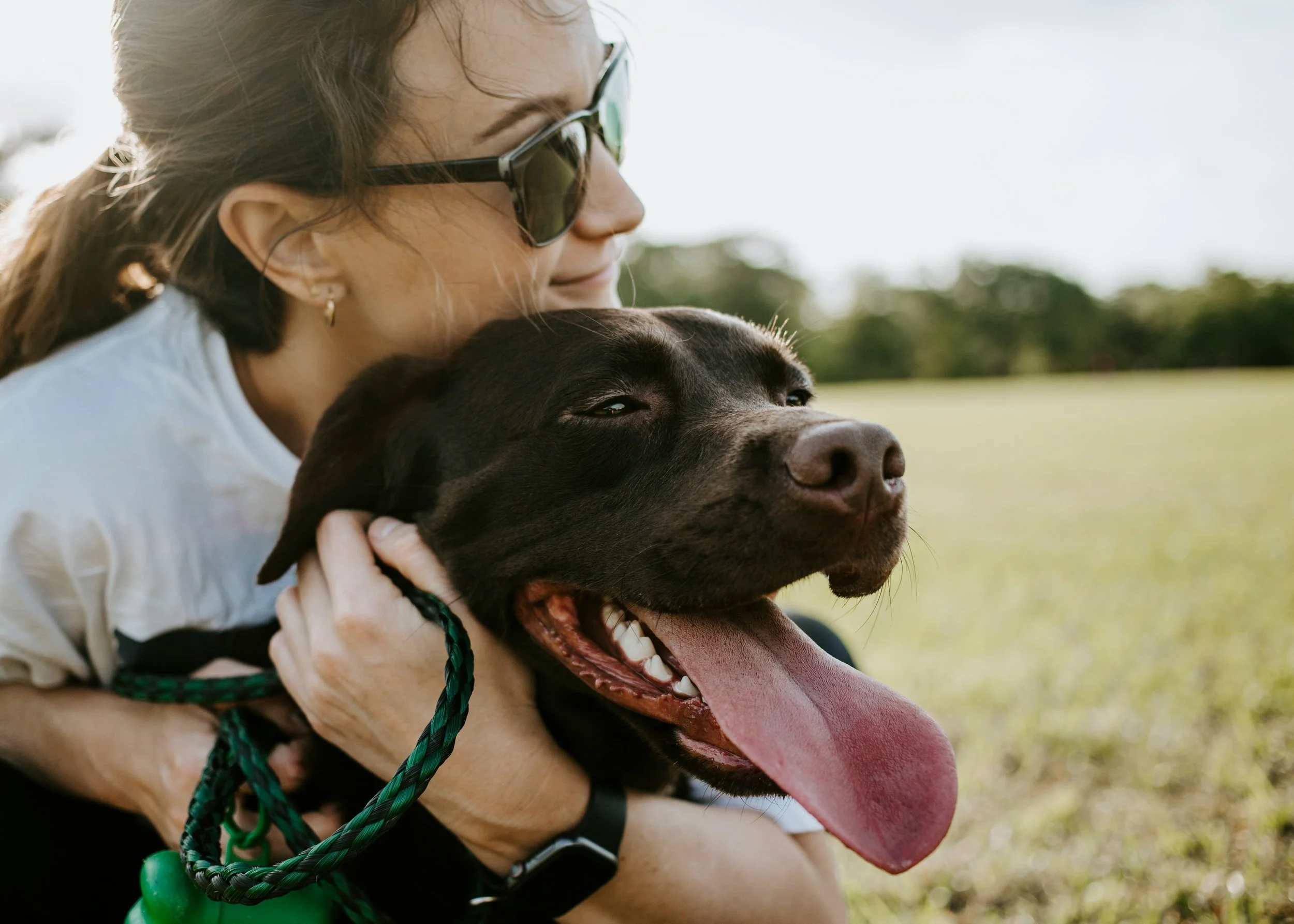 woman holding her dog lovingly after an obidience training session