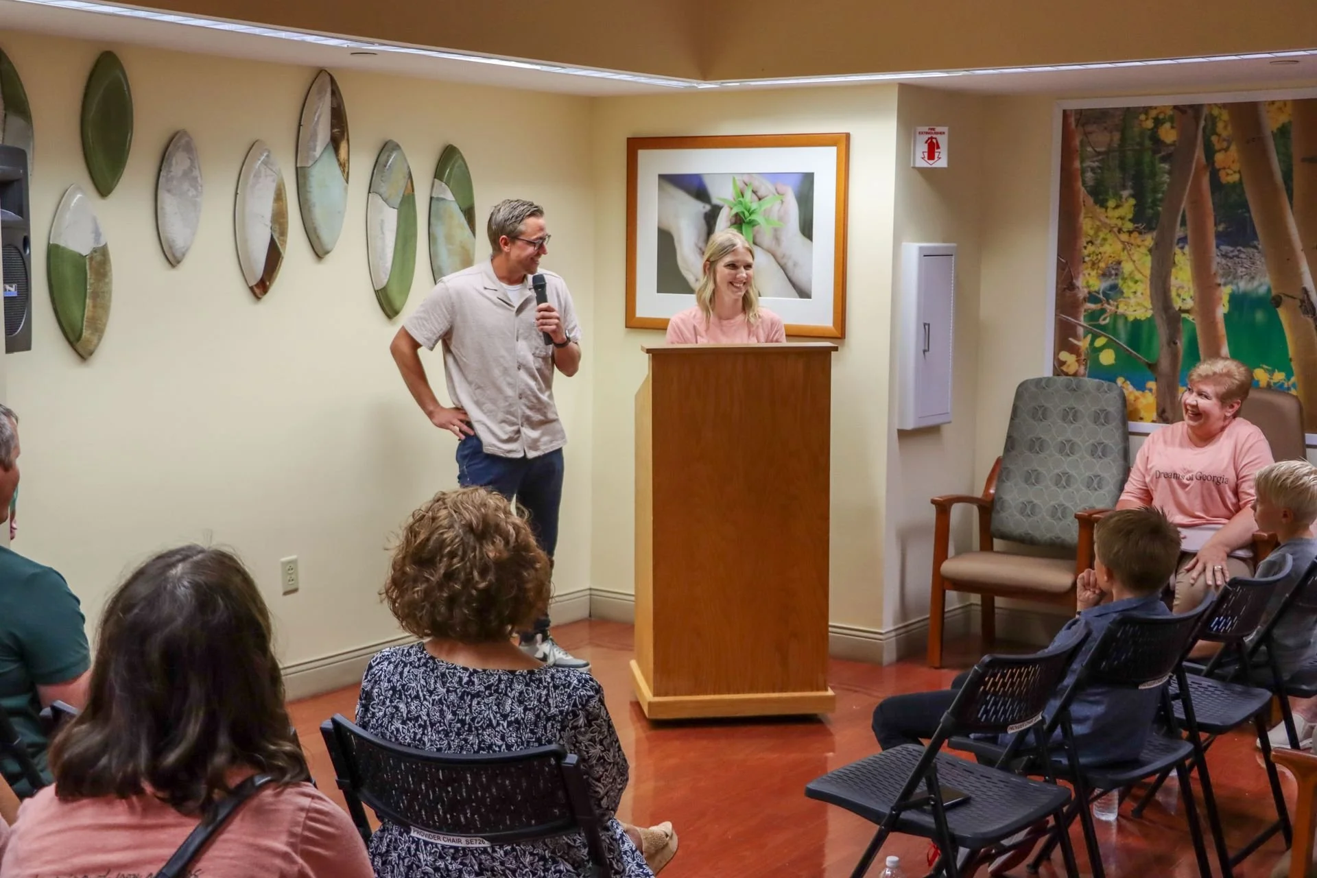 The Chaney family presenting in front of a group of people inside of the Butterfly Room at the Grand Opening.
