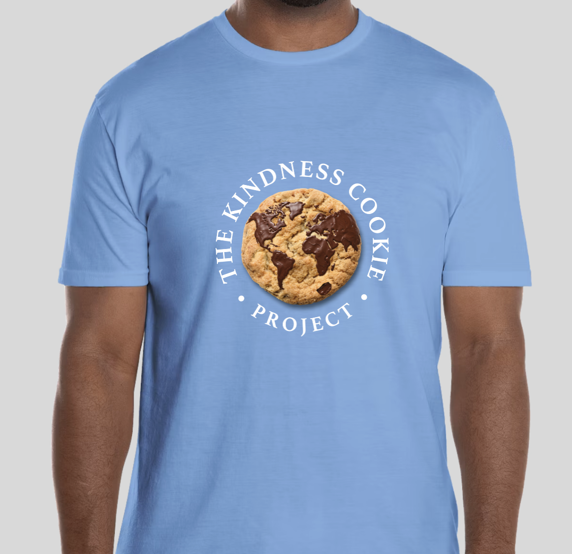 Blue t-shirt with a cookie graphic featuring a world map, and text that reads 'The Kindness Cookie Project'.