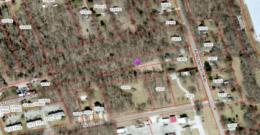 An aerial map showing a wooded area with property lines, lot numbers, and nearby roads.