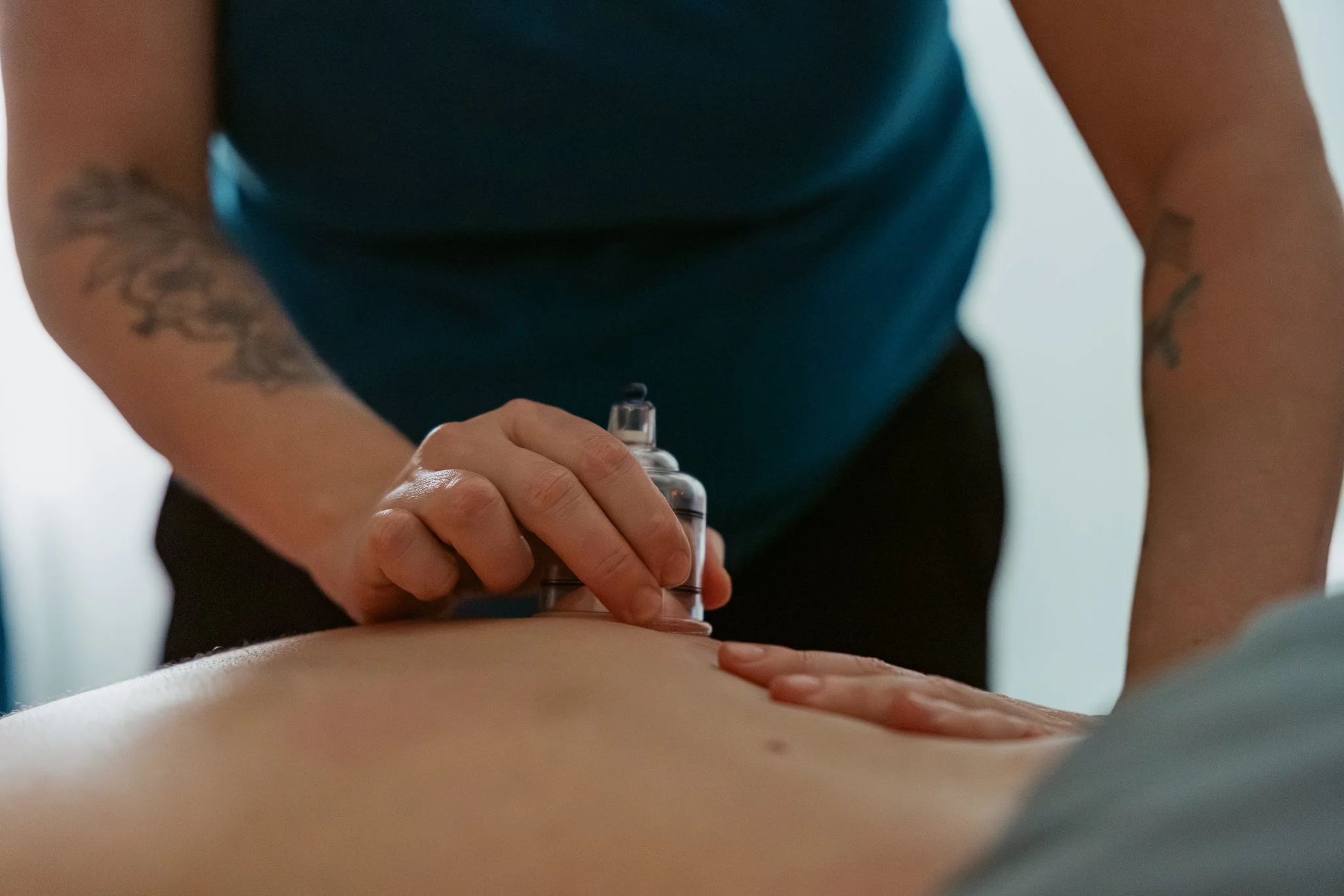 A person receiving a massage on their back in a therapy setting.