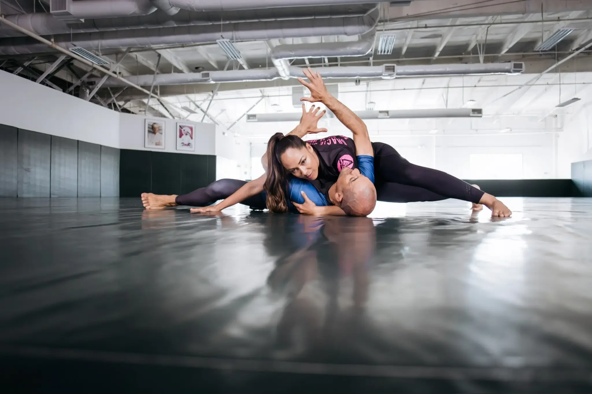 Victoria Gracie practicing Brazilian jiu jitsu techniques with a training partner on the mat, demonstrating self defense skills and physical confidence.