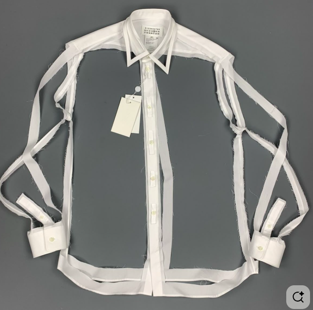 White sheer long-sleeve button-up shirt with collar and tag attached, laid flat on a gray surface.