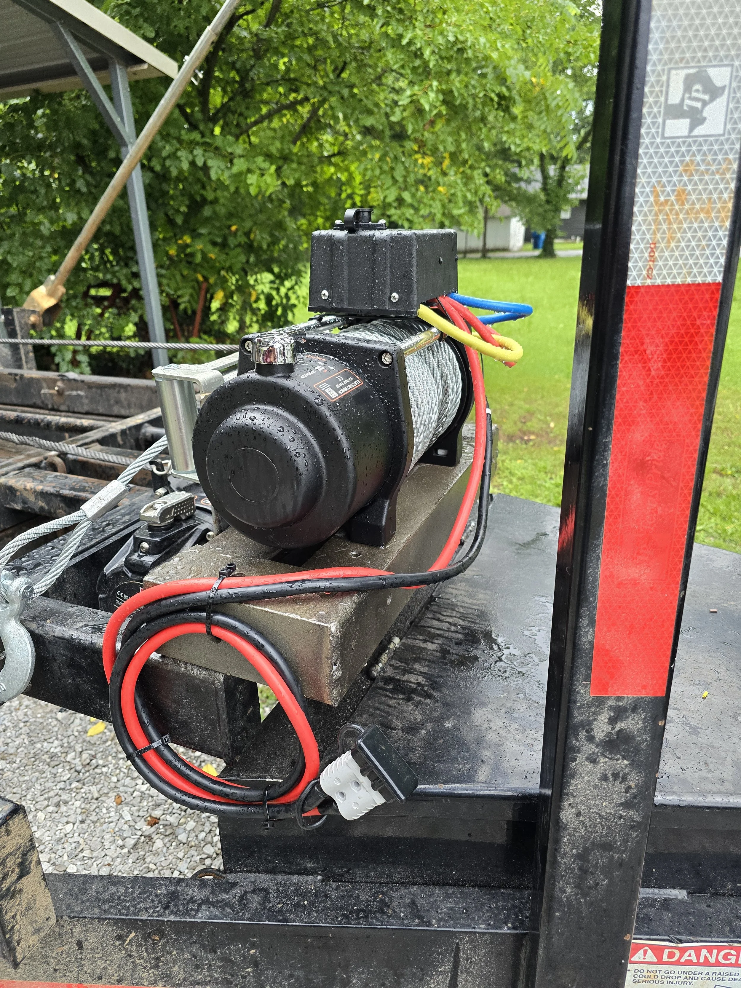 Close-up view of spare accessory winch which was added to junk removal trailer. Technician ran new quick connect wiring for winch and welded a sturdy box frame that spare winch mounts to.