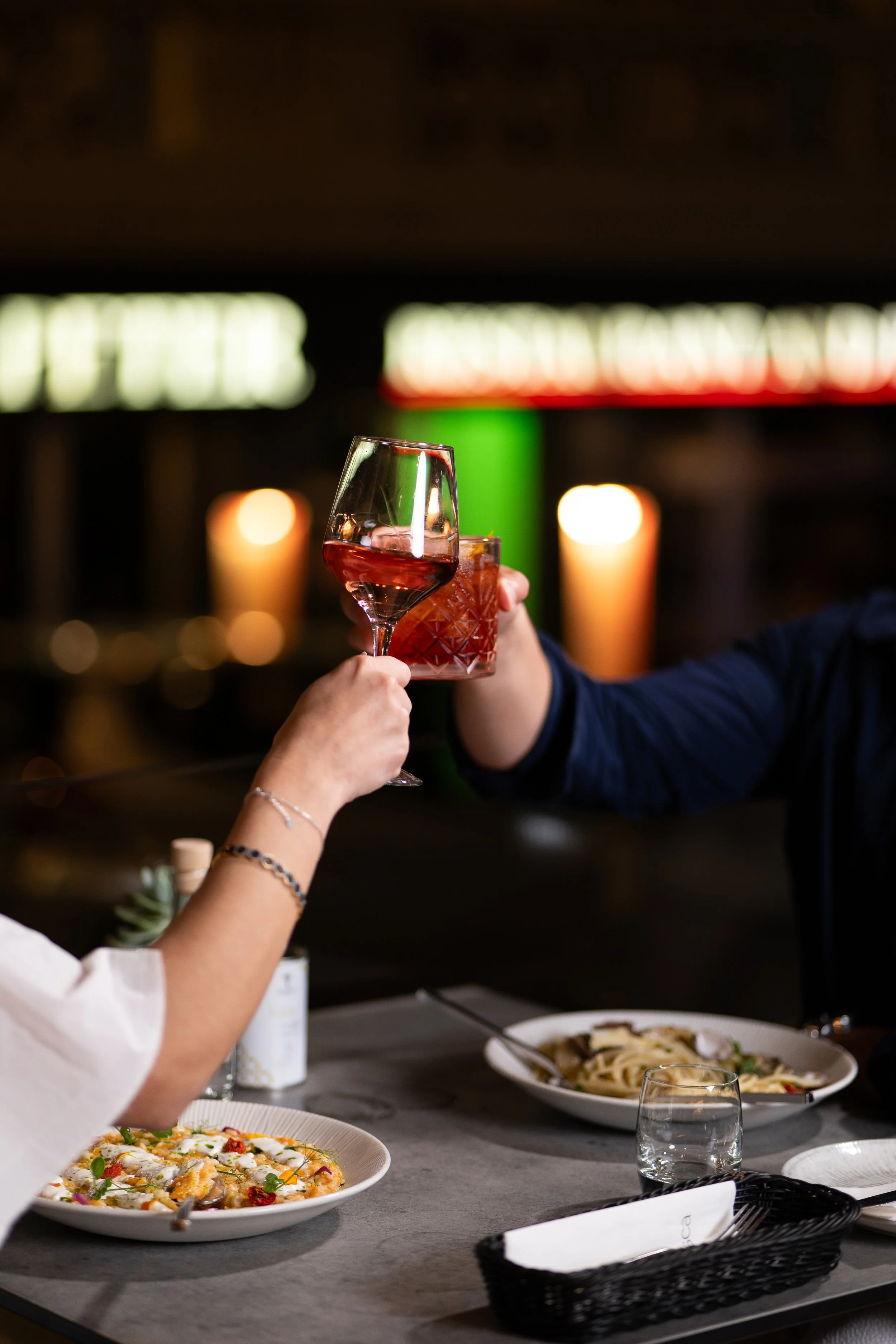 Hospitality lifestyle photography featuring guests raising a toast over dinner, capturing authentic restaurant moments for hospitality marketing.