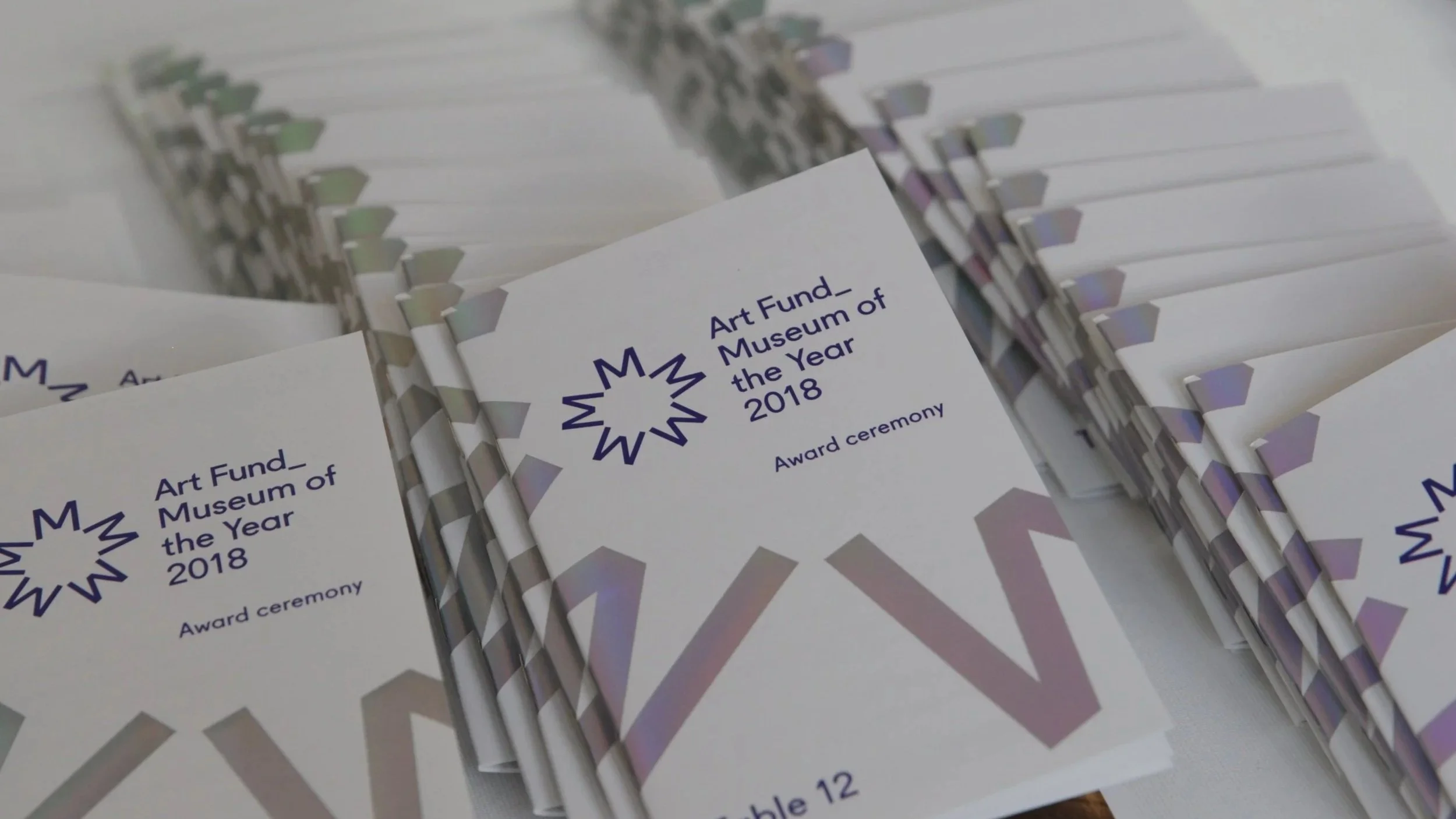 Several award booklets titled 'Art Fund Museum of the Year 2018' arranged in a pile.