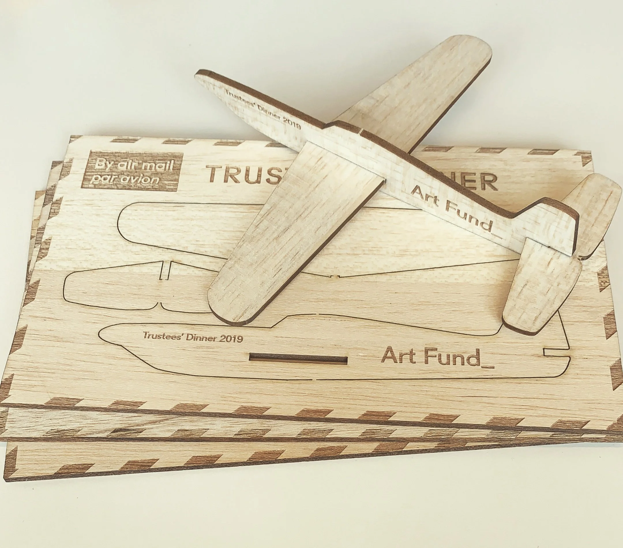 Stacked wooden boxes with engraved text, including 'Trustees' Dinner 2019,' 'By air mail,' and 'Art Fund'