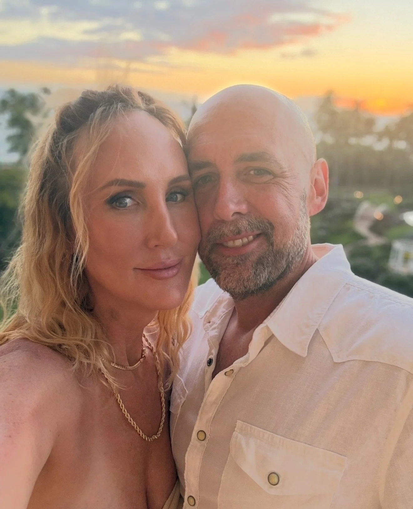 Adam and Stacy in Hawaii with a sunset as the backdrop.