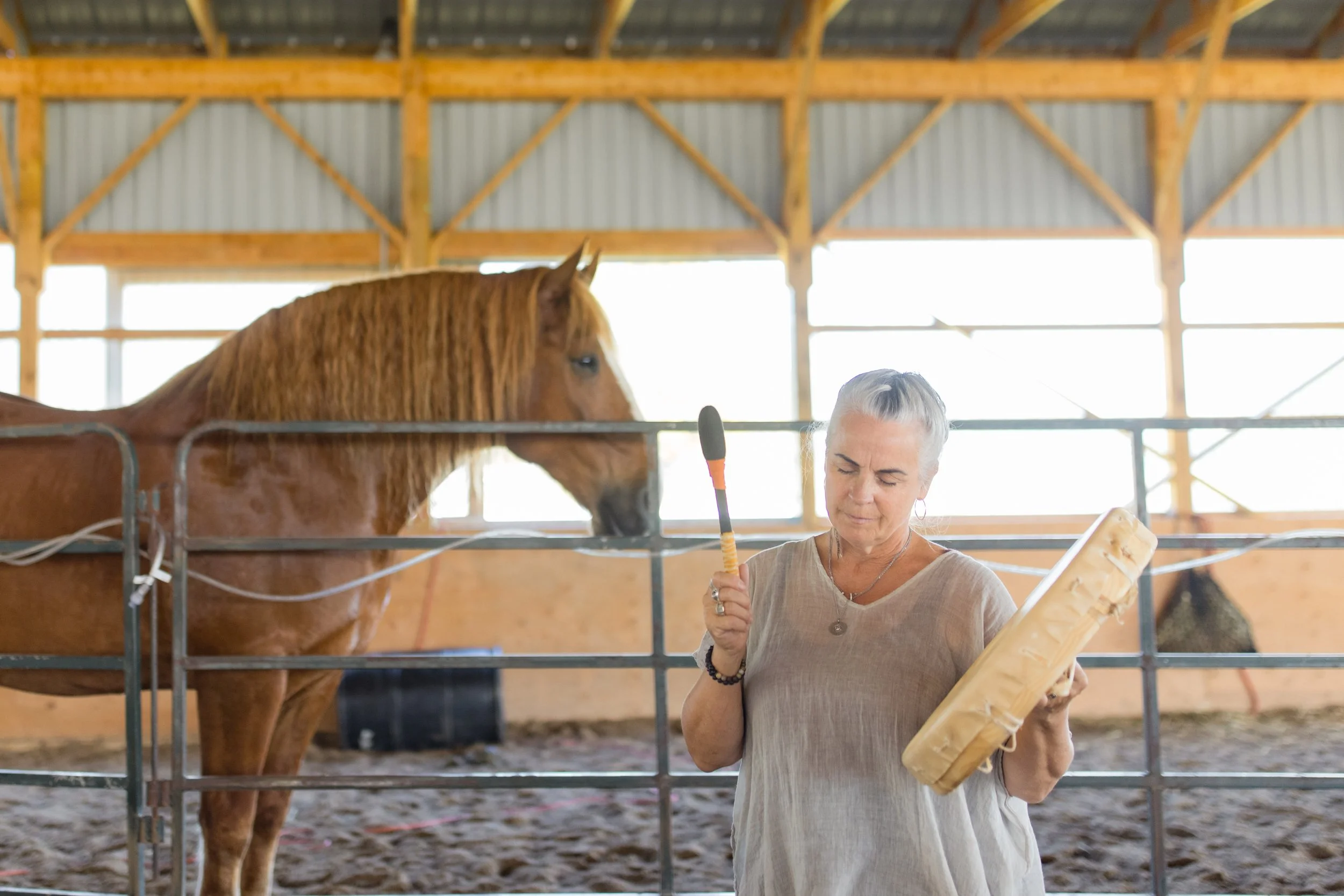 Doe plays a hand drum for one of the Healing Herd horses during a sound healing meditation session at For the Love of the Horse and Yourself of Course.