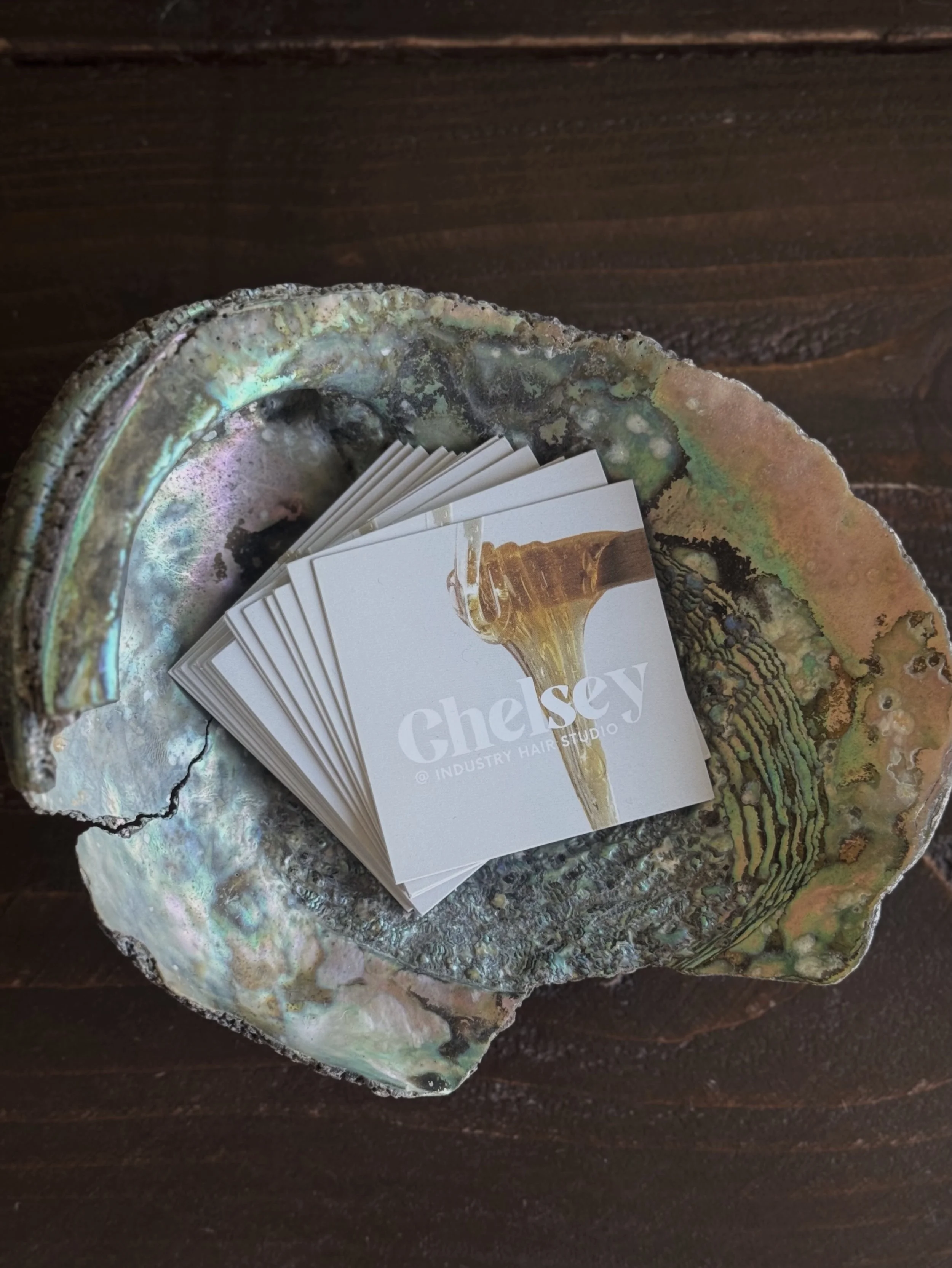 A close-up photo of a stack of business cards for clients looking for lash lifts, waxing, brazilian waxing in captiola, santa cruz or aptos areas.