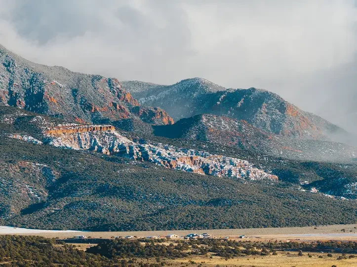 Southern Utah mountain landscape with snow-capped peaks and a cloudy sky.
