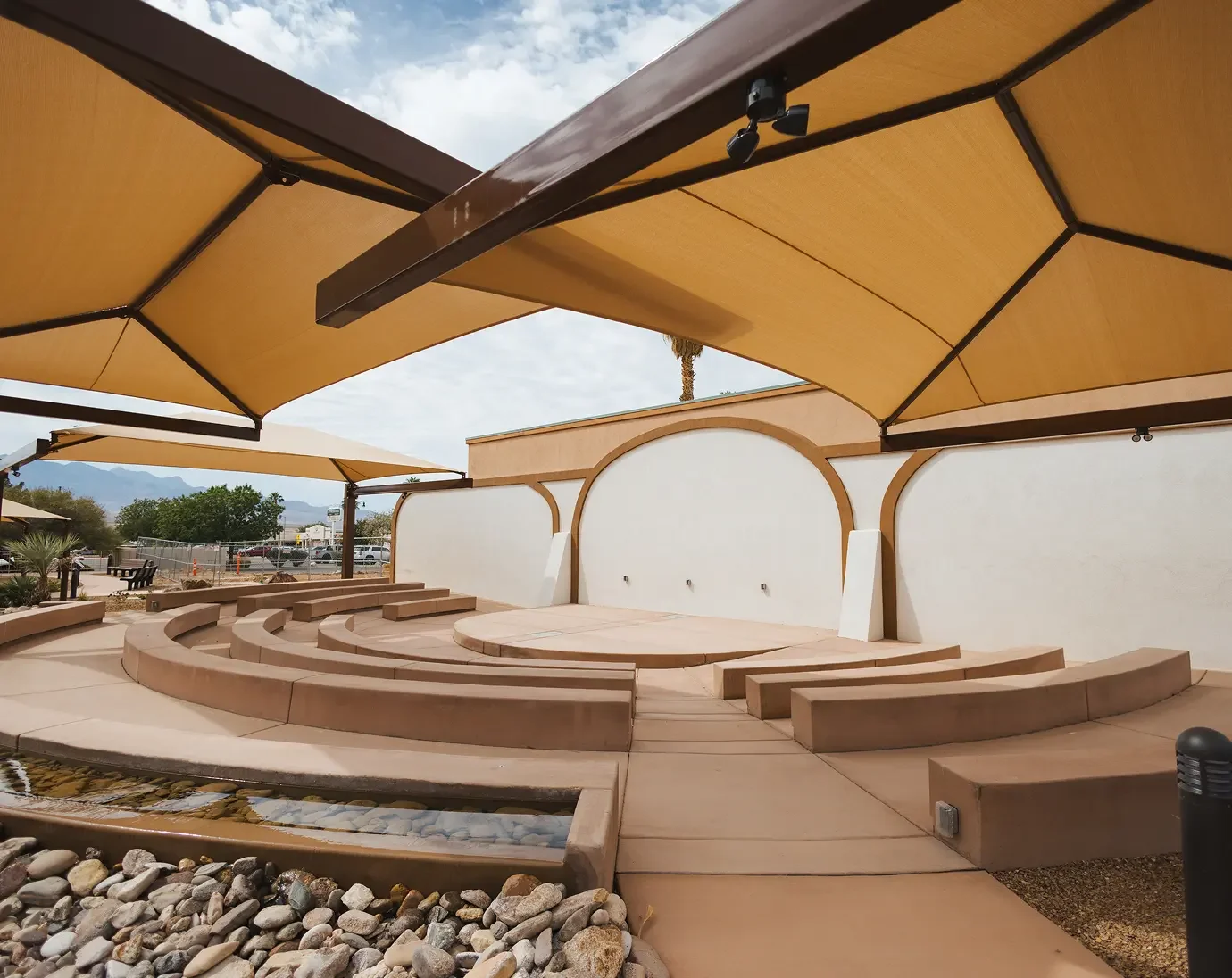 Virgin Valley Utah Outdoor amphitheater with curved concrete seating and large yellow umbrellas for shade.