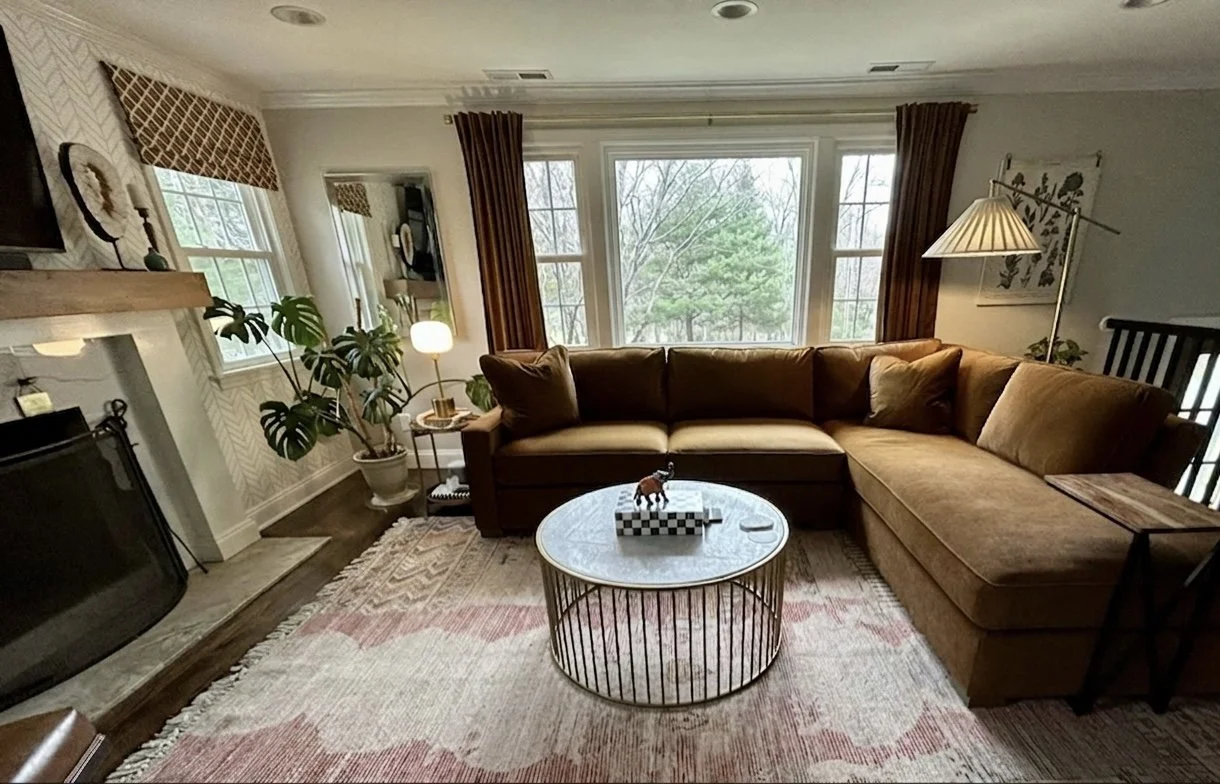 An inviting living room transformed by added windows flanking the fireplace and new furnishings create a layered space.
