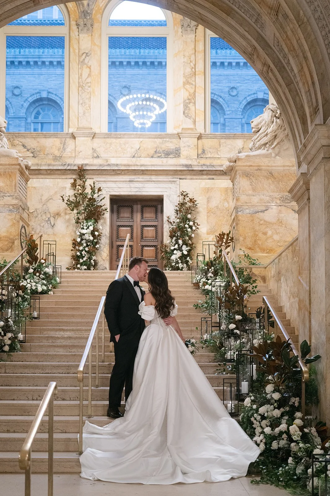 Bride and groom sharing a kiss on the stairs of the Boston Public Library