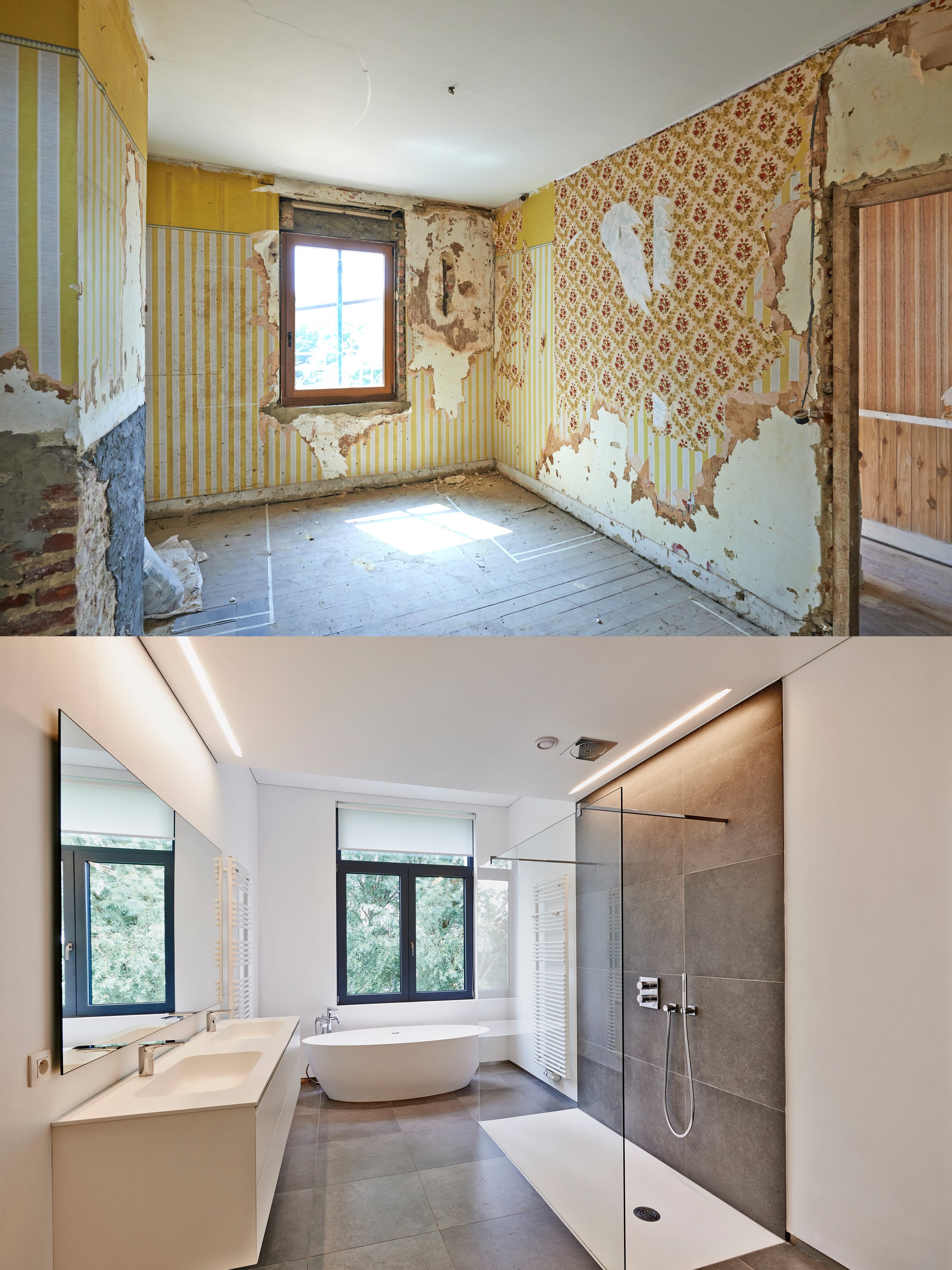 Modern renovated bathroom with white walls, large gray tiles, double sinks, a freestanding bathtub, and a walk-in shower with gray tiles. Large windows with black frames provide natural light, and the space is decorated with minimalistic fixtures and a clean aesthetic.